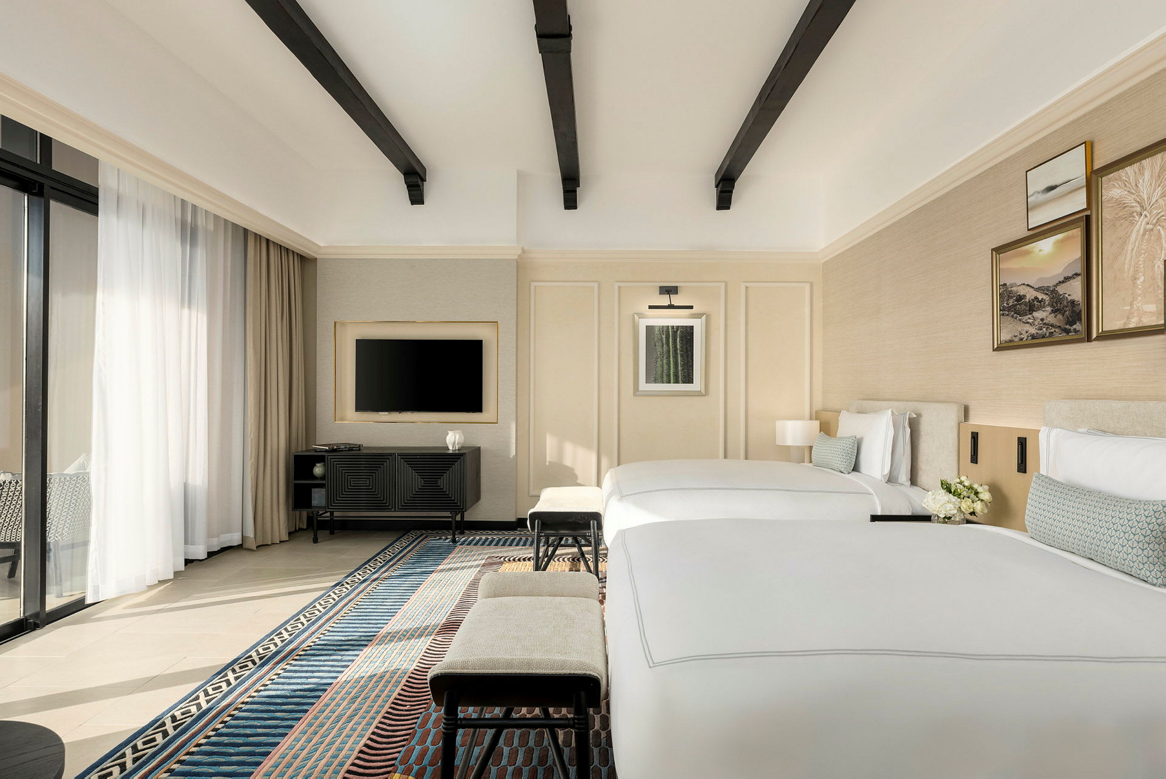 Et moderne hotelværelse med to enkeltsenge, et tv på væggen og et vindue med gardiner. (AI-genereret tekst)