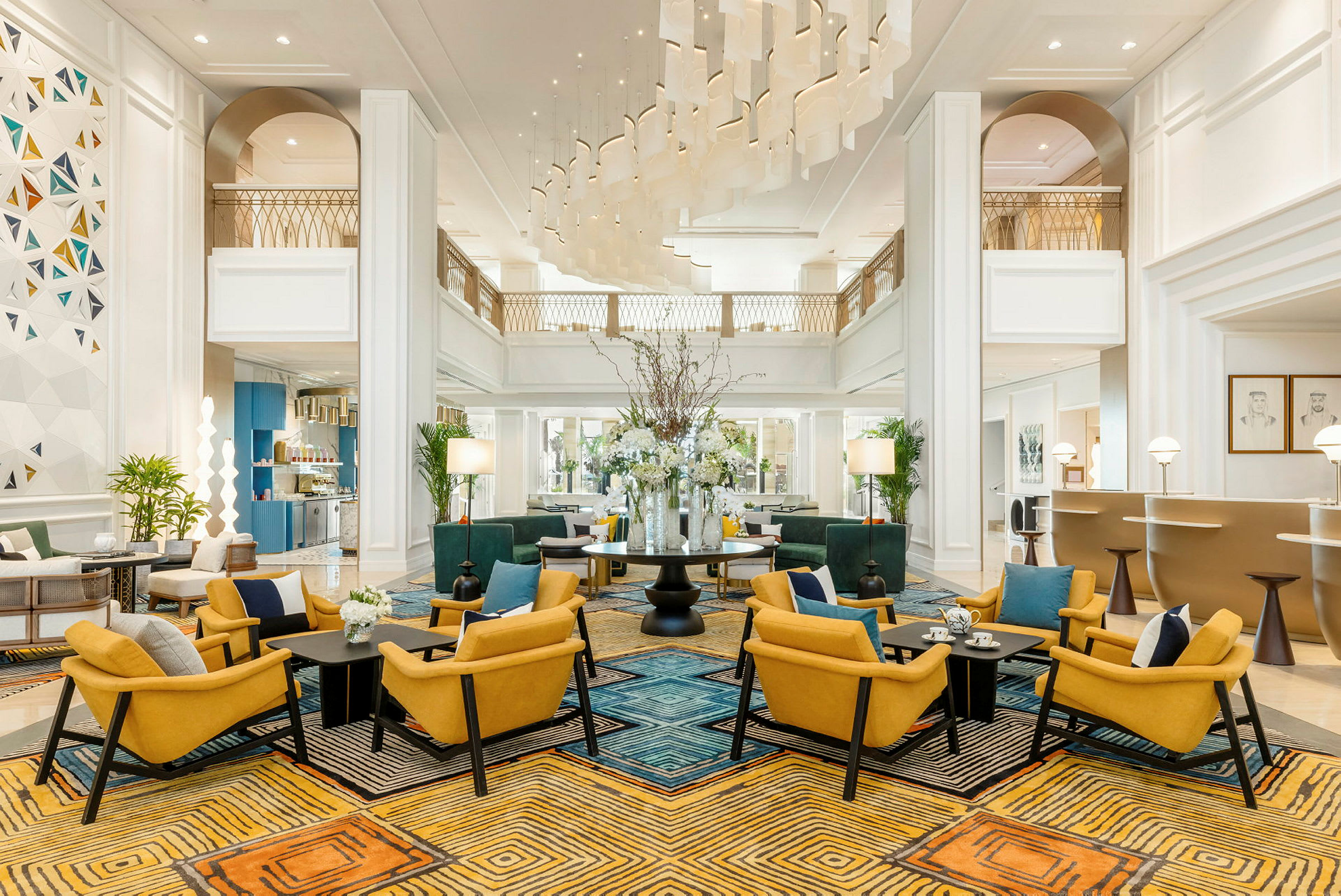 Lys og elegant hotellobby med siddegrupper og blomster på et bord. (AI-genereret tekst)