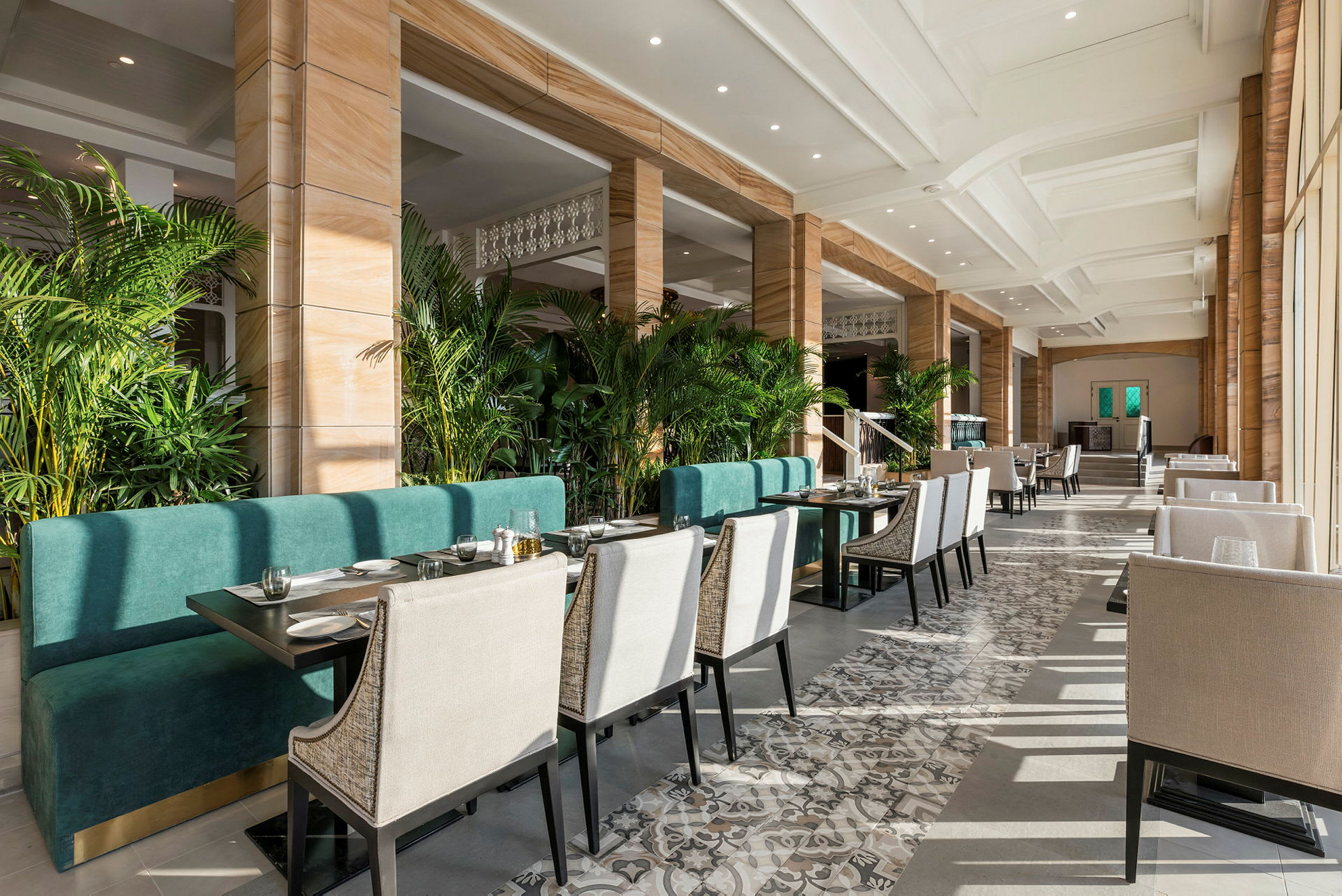 Restaurant med siddepladser og grønne planter. (AI-genereret tekst)