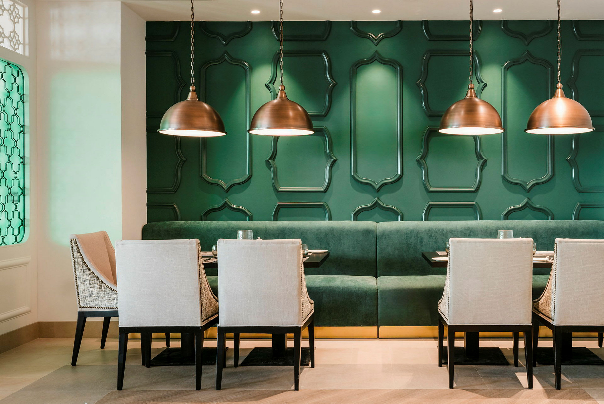 En moderne designet restaurant med grønne vægge og elegante møbler. (AI-genereret tekst)