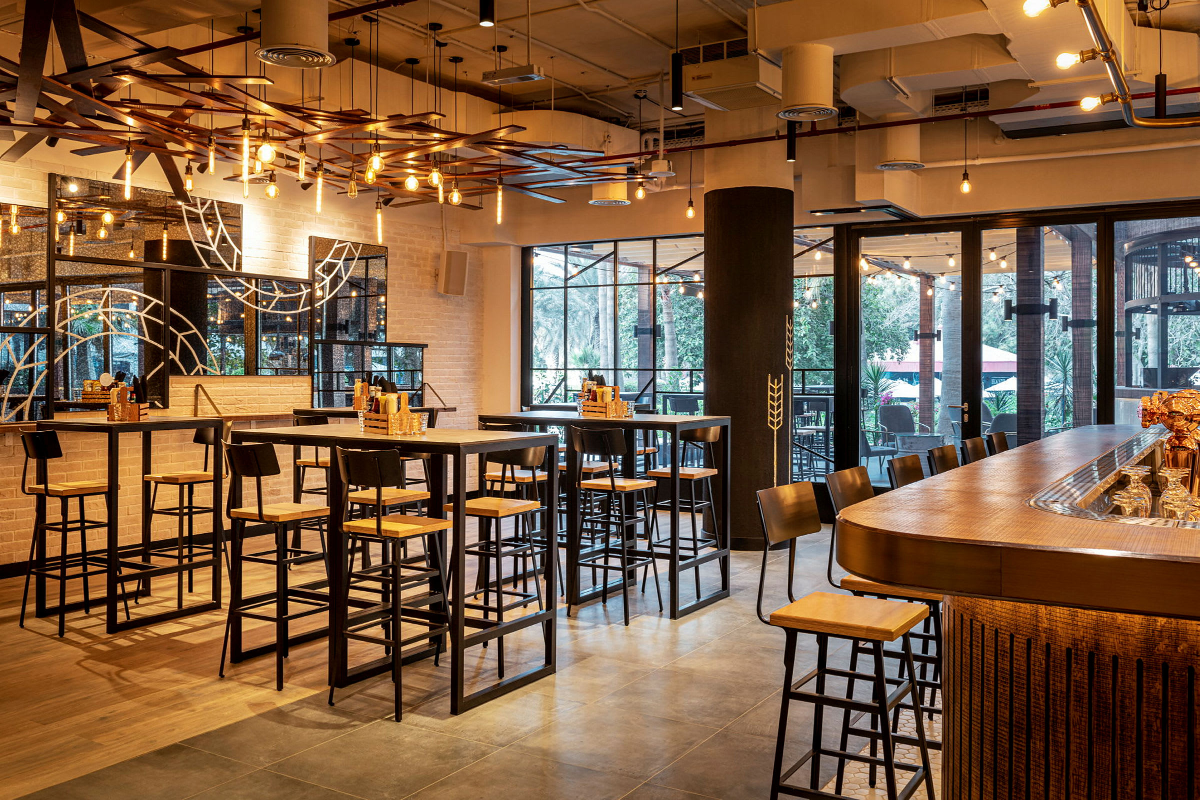 En indendørsrestaurant med højborde og barstole under moderne belysning. (AI-genereret tekst)