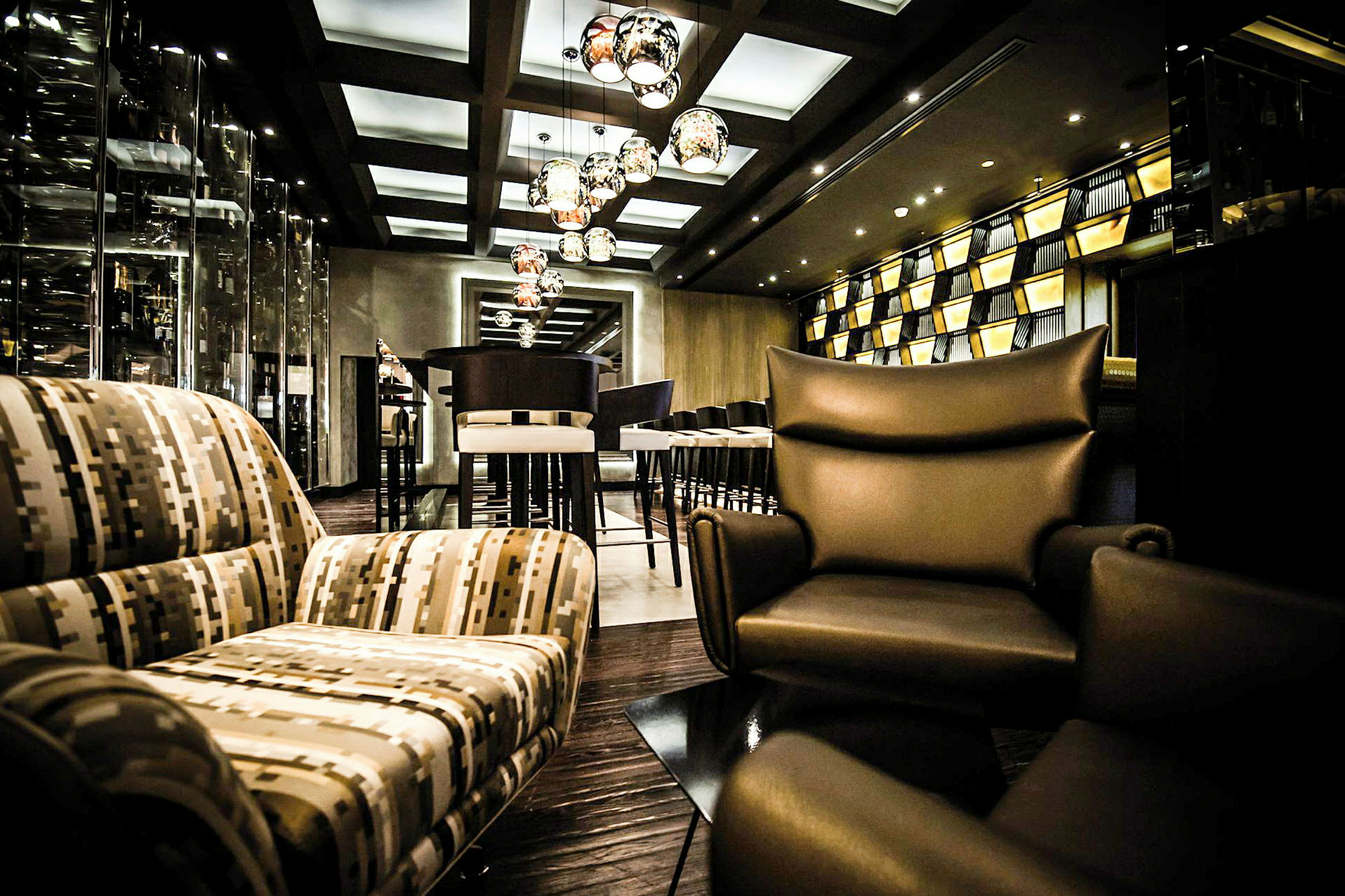 Billede af en stilfuldt indrettet lounge med moderne siddepladser, hængende lamper og en velplejet atmosfære. (AI-genereret tekst)