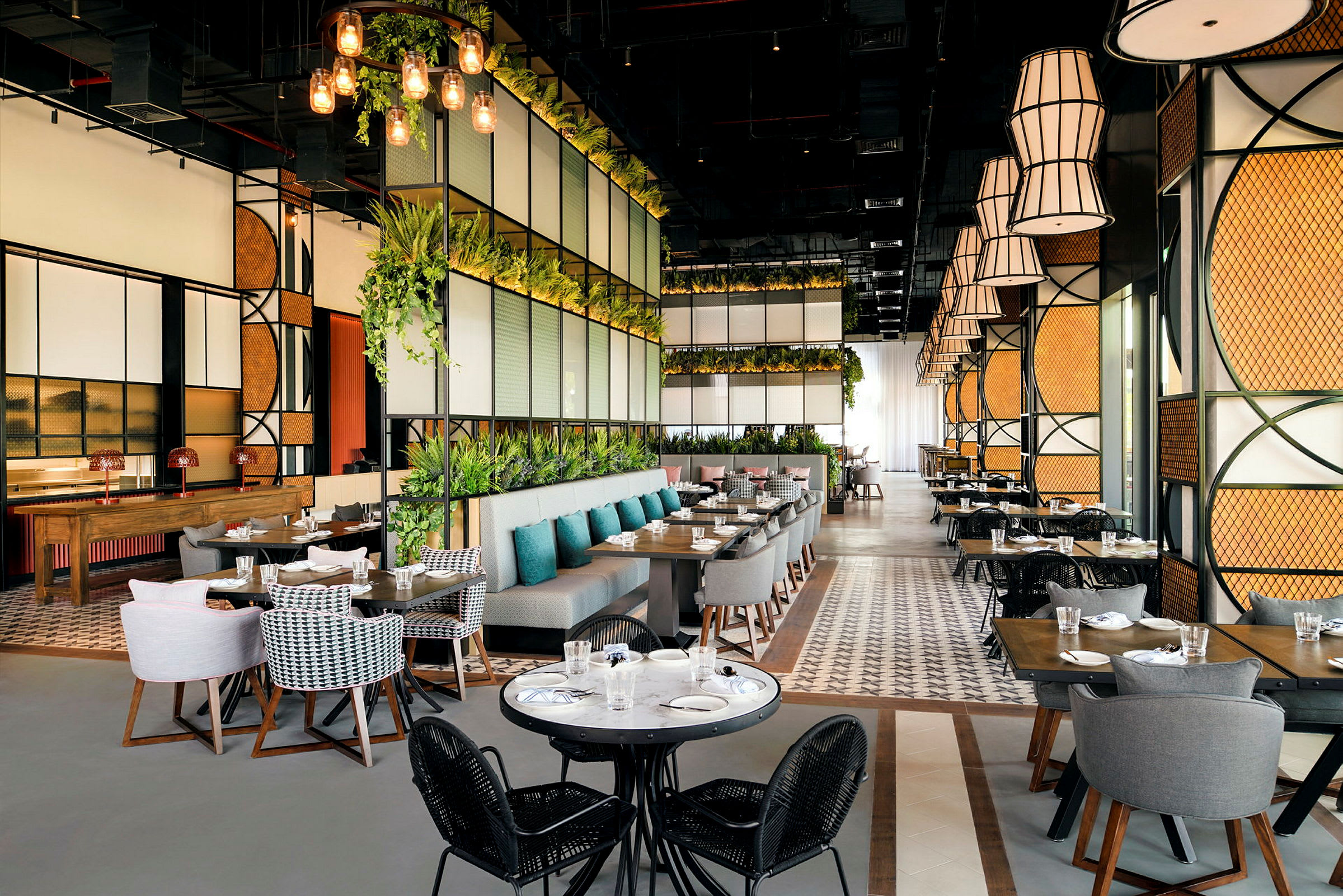 En moderne restaurant med store vinduer, grønne planter og elegante siddepladser. (AI-genereret tekst)