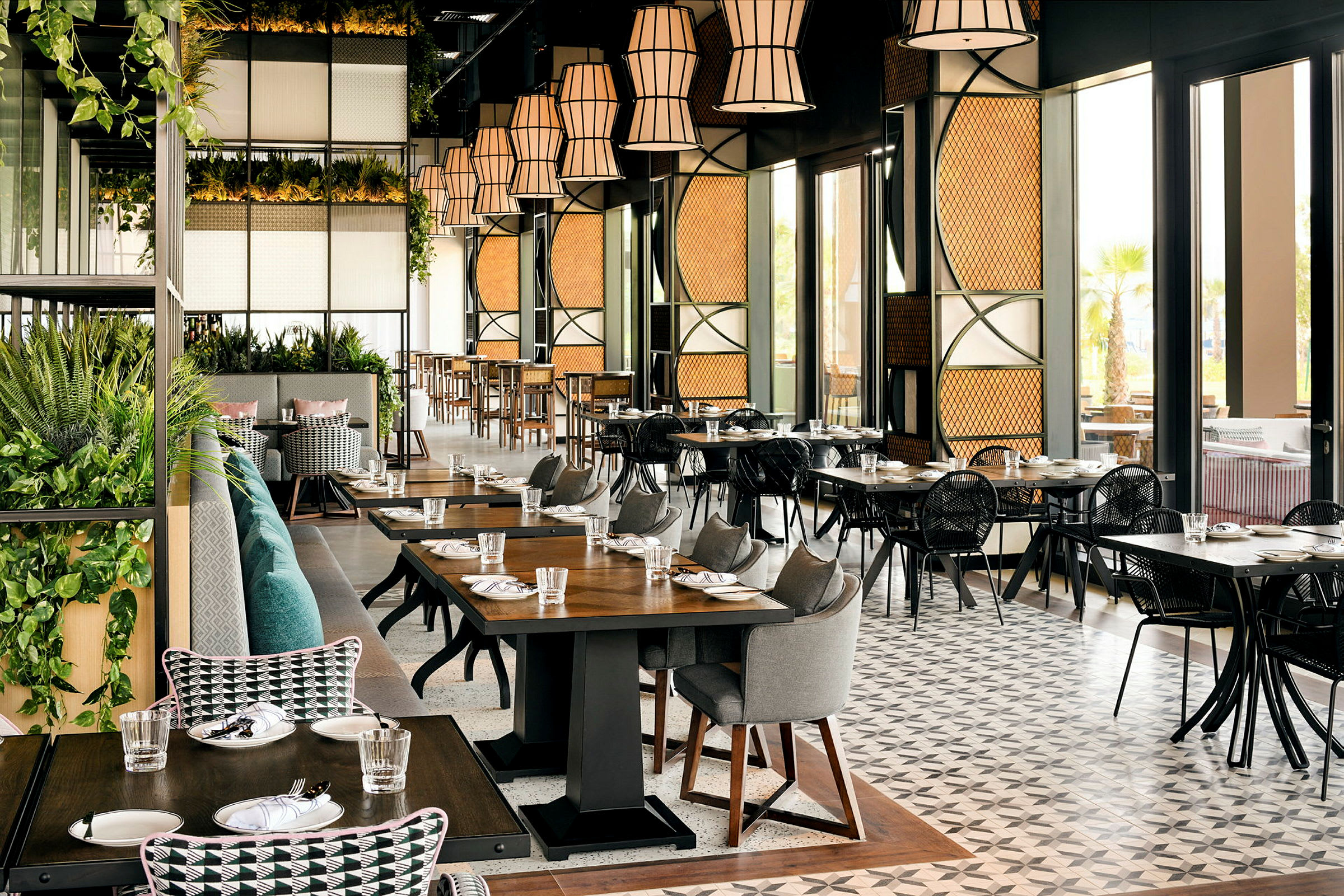 Interiør af en moderne restaurant med borde og stole samt dekorationer. (AI-genereret tekst)