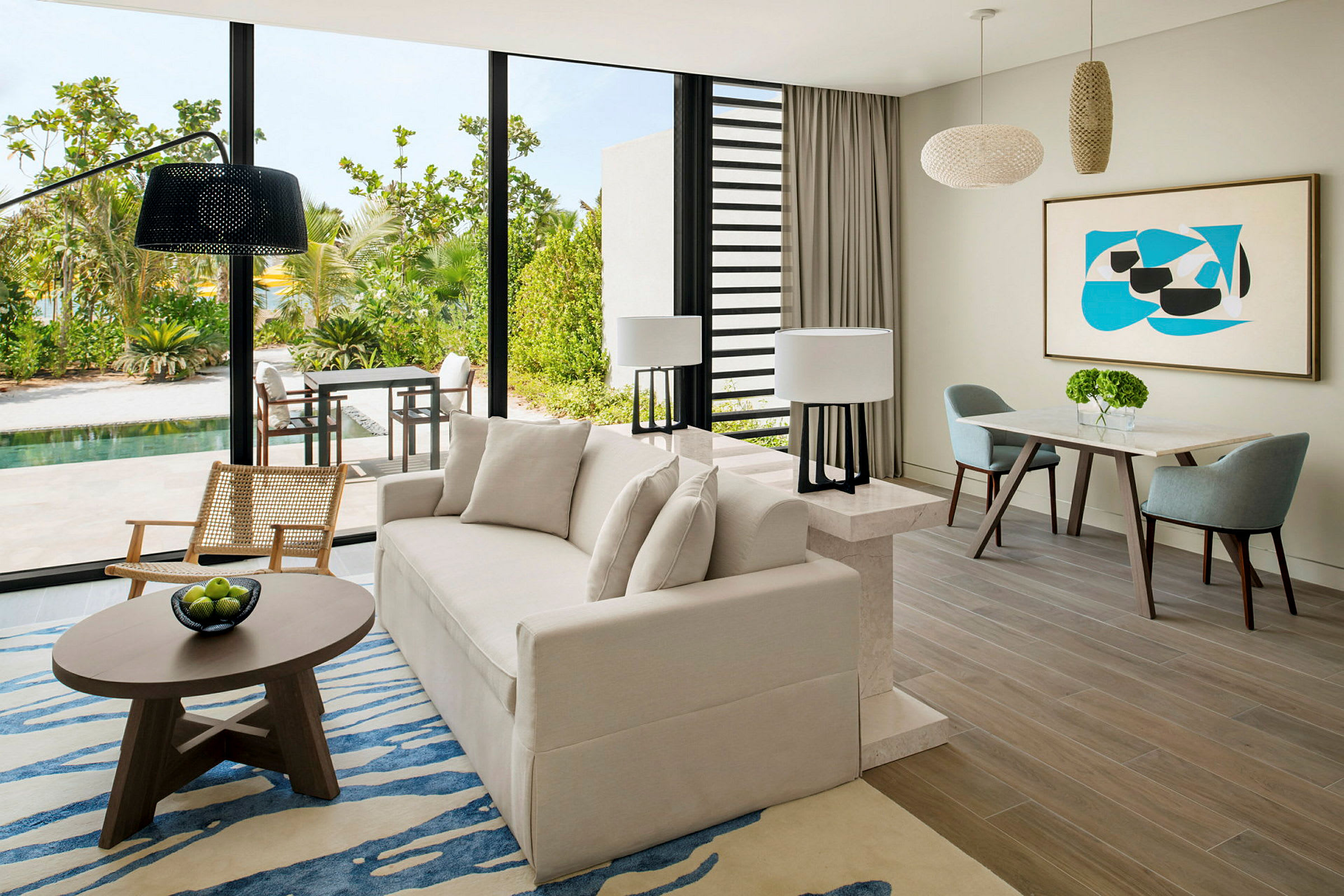 Moderne stue med stor sofa, lænestol og spisebord samt udsigt til en terrasse med grønt og pool. (AI-genereret tekst)