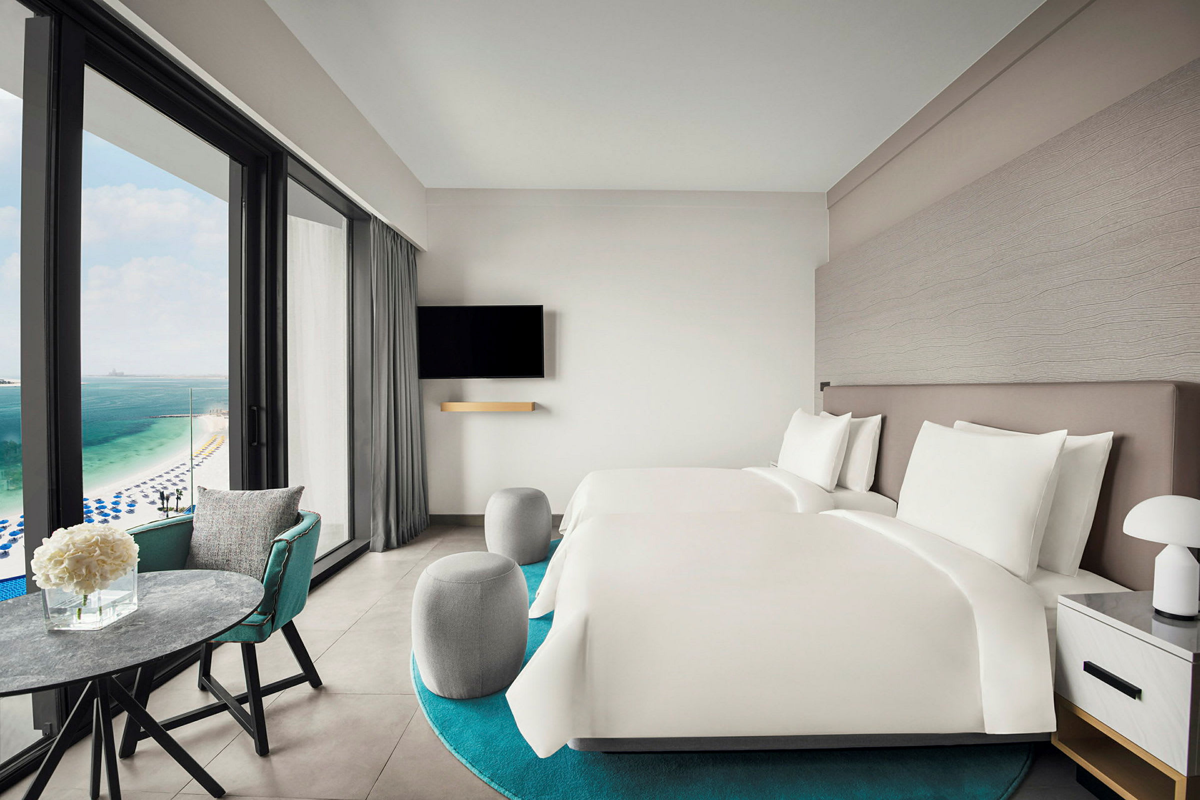 Hotelværelse med to senge og udsigt over havet. (AI-genereret tekst)