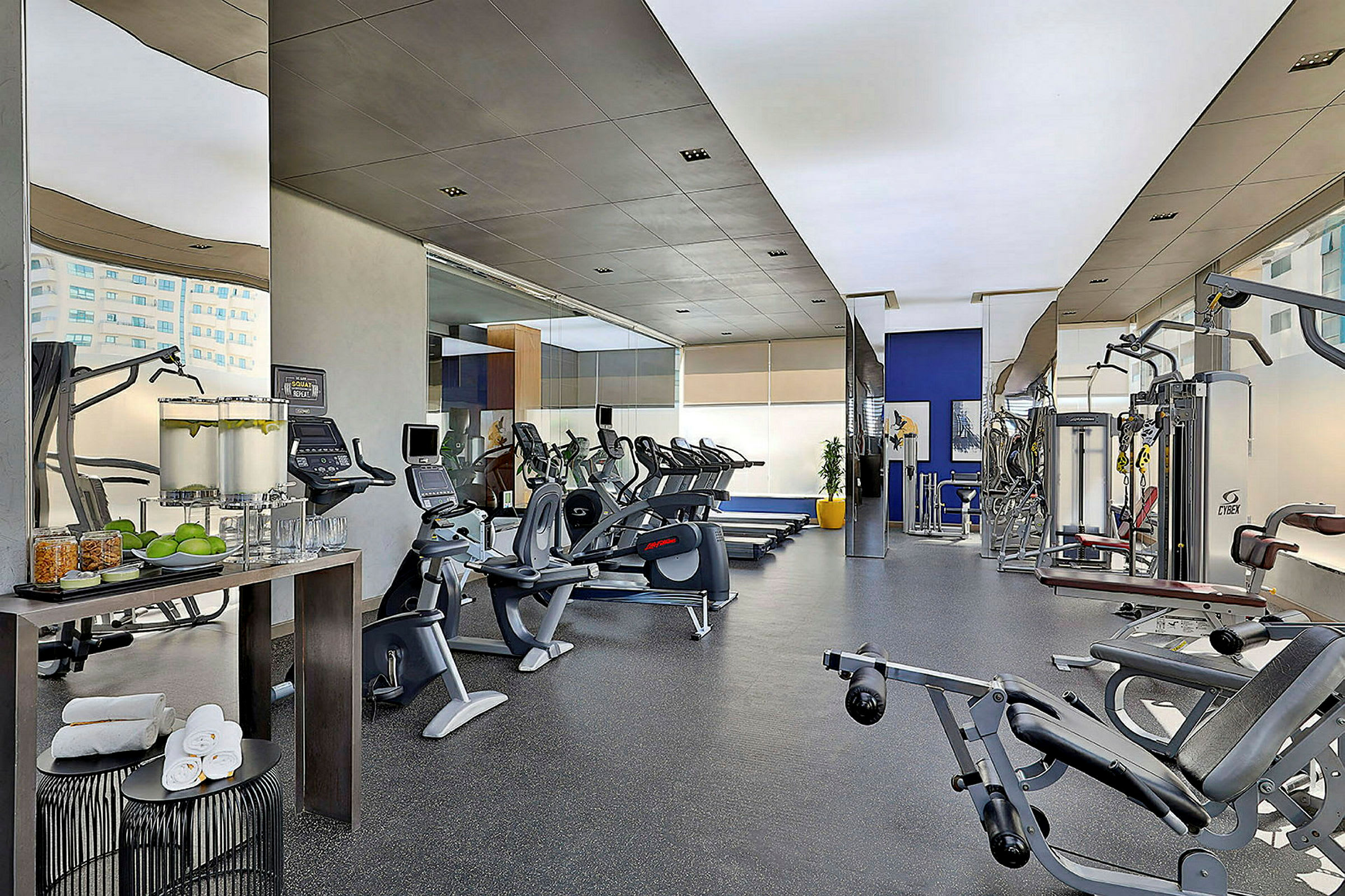 Et fitnesscenter med forskellige træningsmaskiner og en vandstation. (AI-genereret tekst)