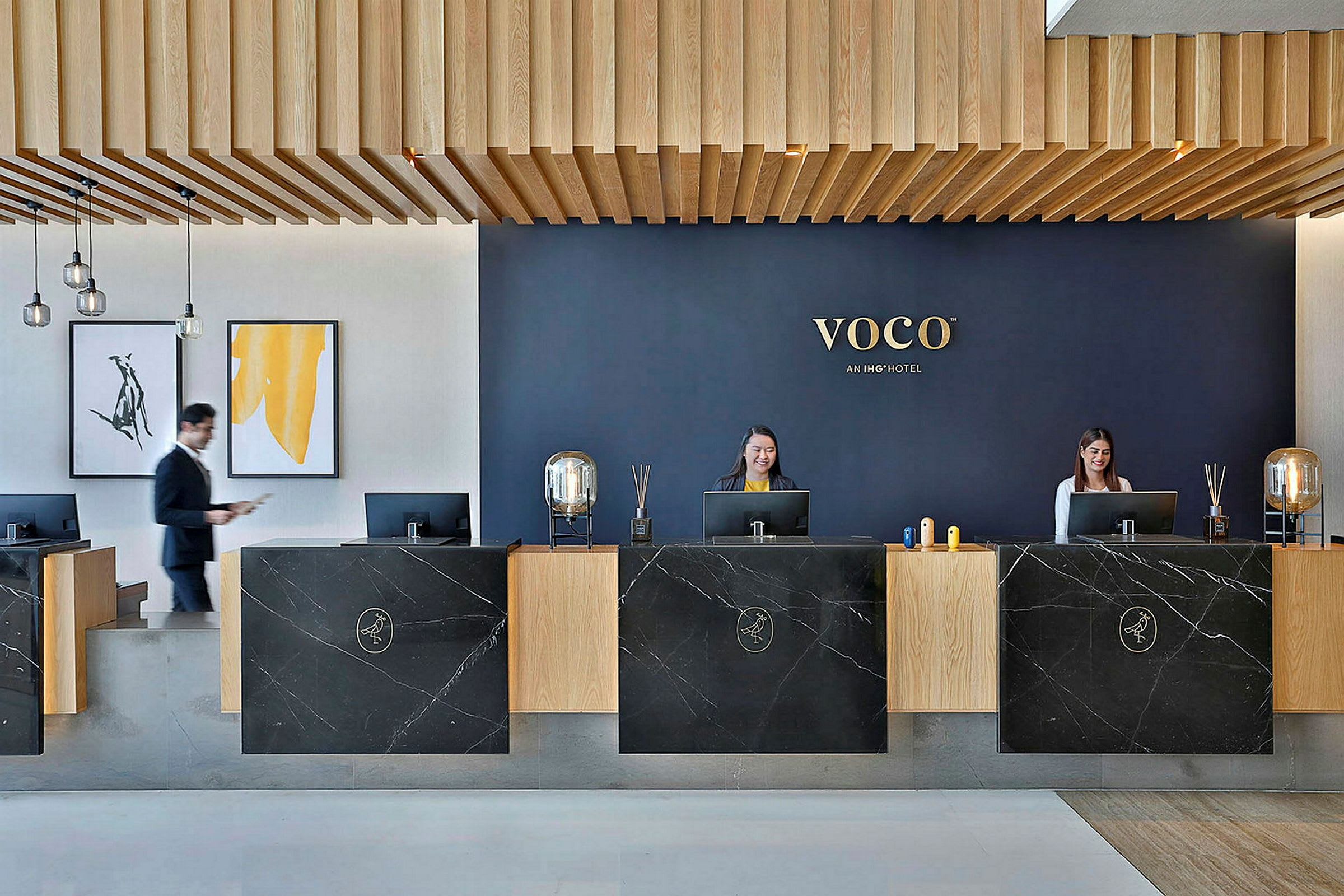 Receptionen på et hotel med moderne design, mørke marmorborde og trælofter. (AI-genereret tekst)