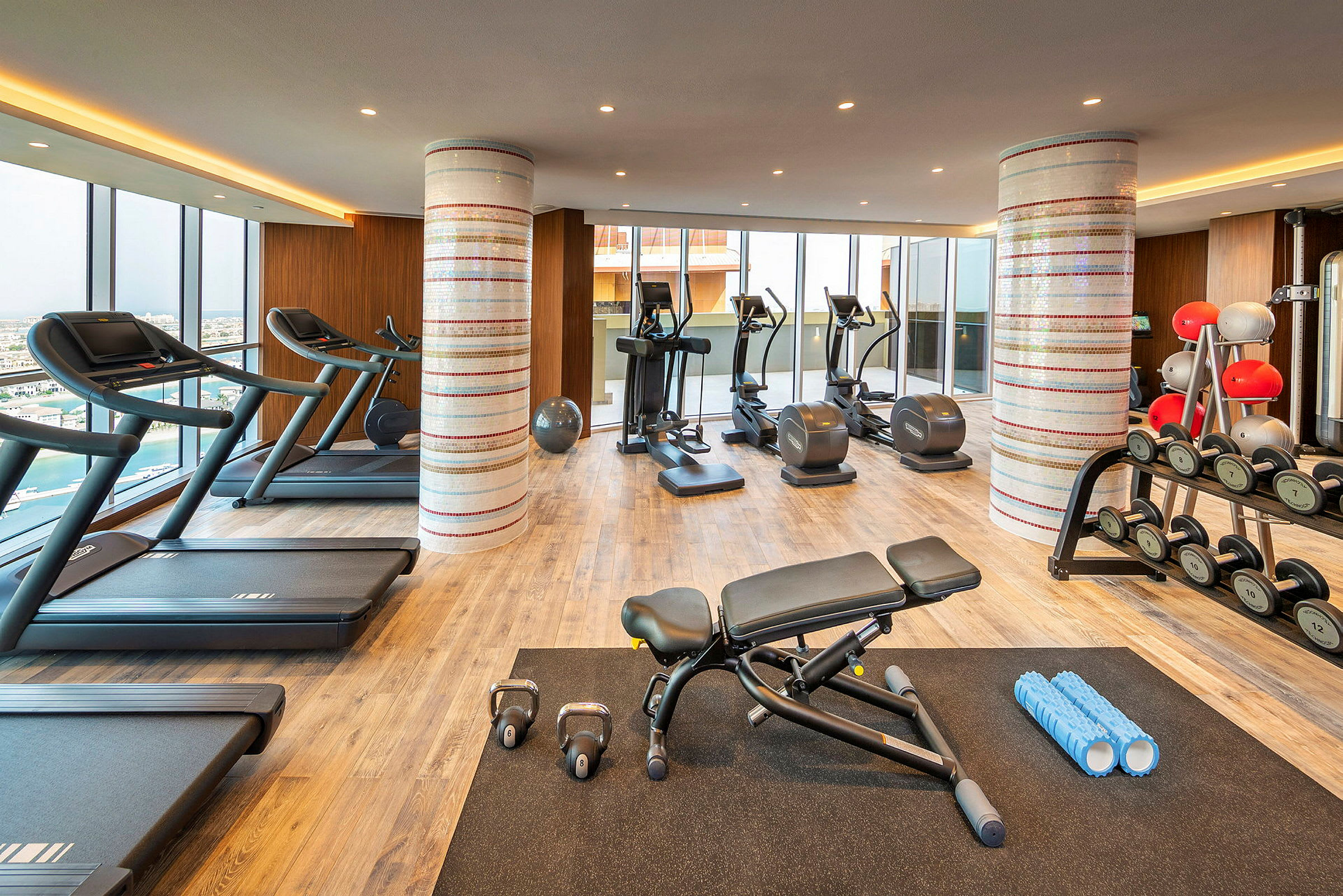 Et fitnesscenter med træningsudstyr, herunder løbebånd, motionscykler, vægte og andet udstyr. (AI-genereret tekst)