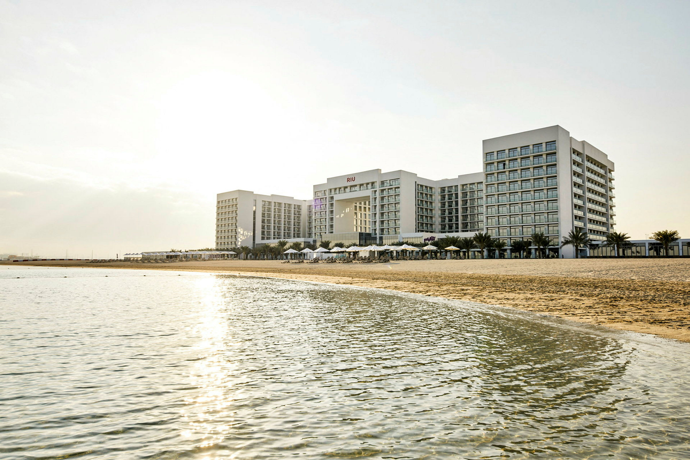Et stort hotelkompleks ved en strand med havet i forgrunden. (AI-genereret tekst)