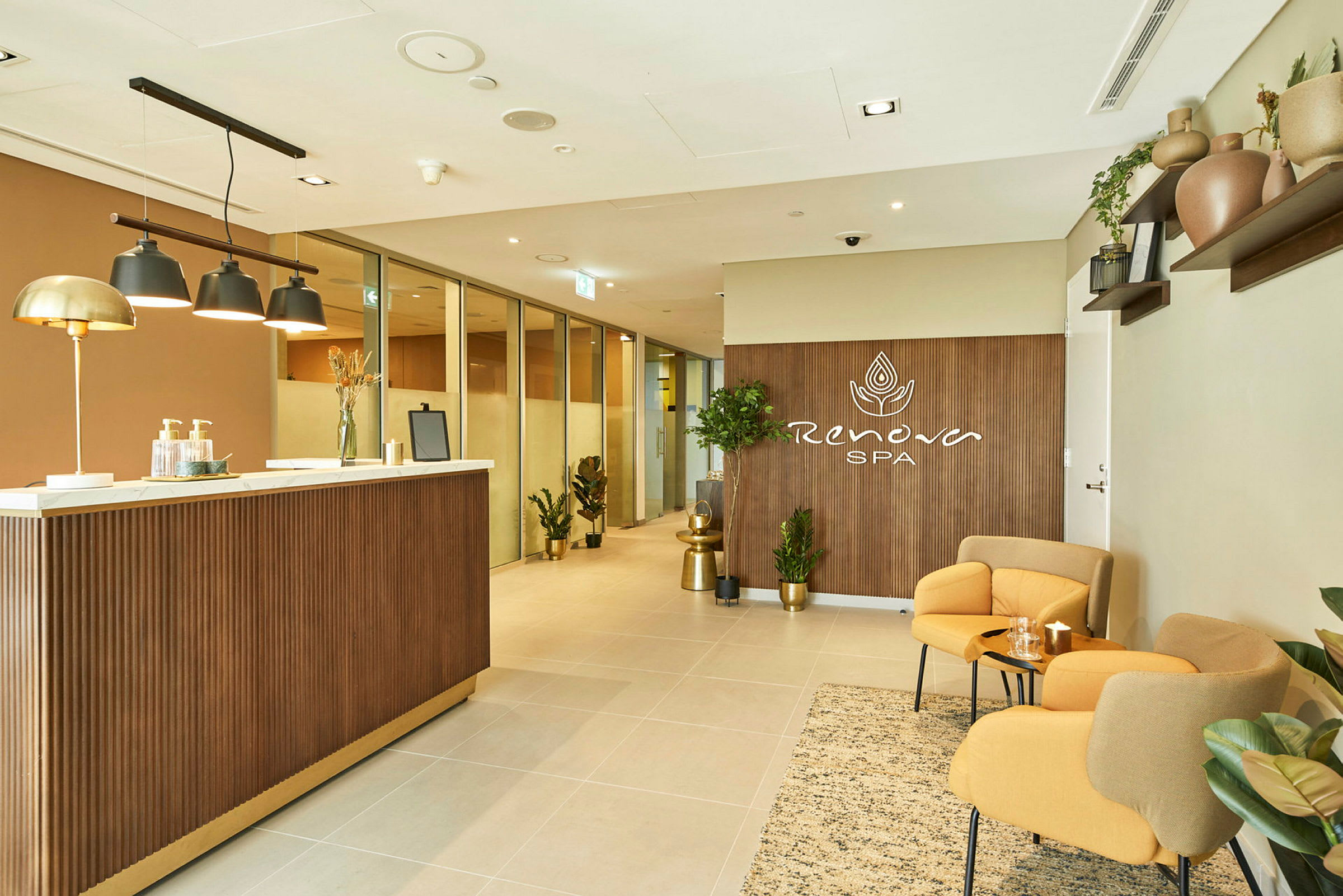 Billede af et spa-receptionsområde med en skranke, siddepladser og planter. (AI-genereret tekst)