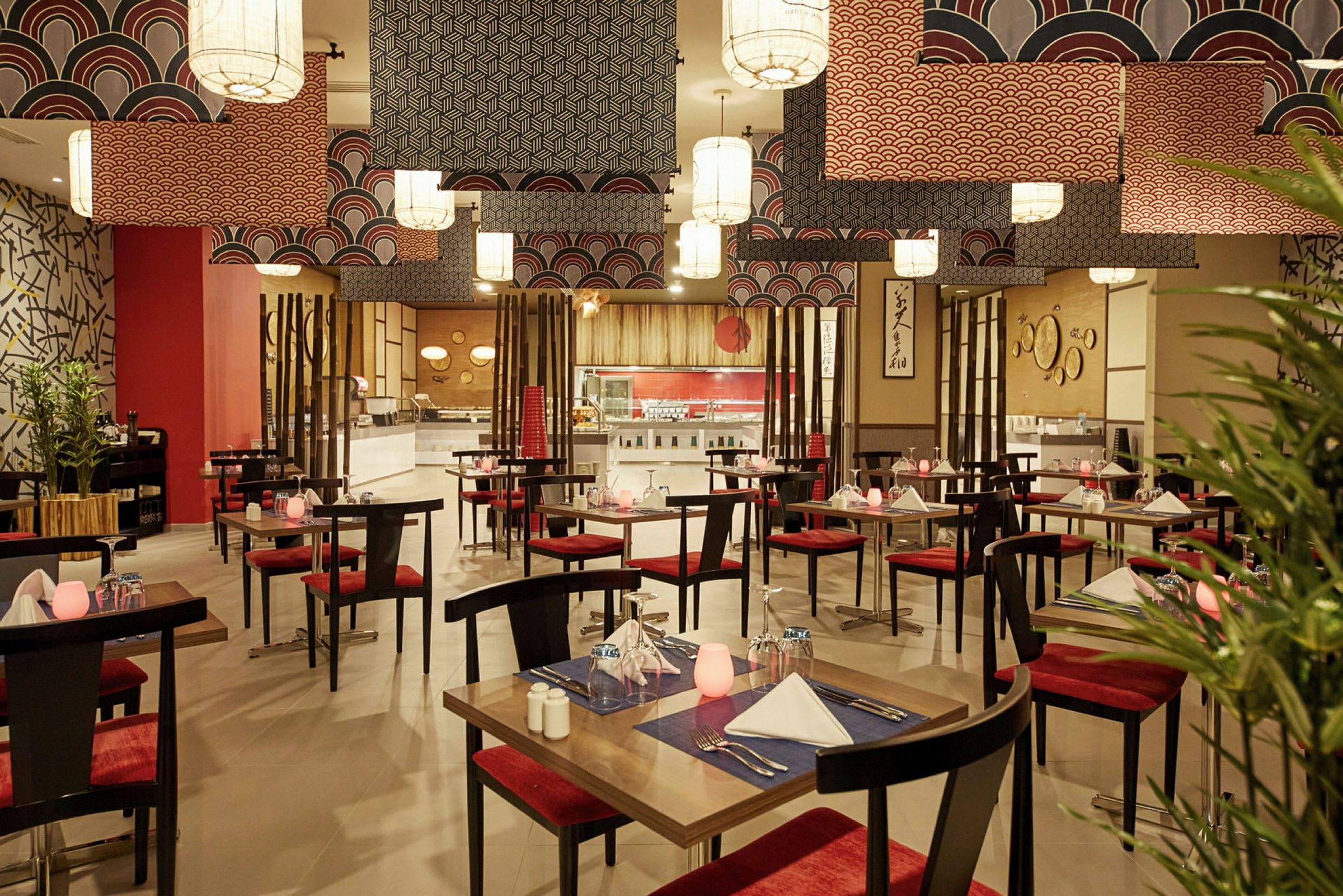 En restaurant med borde og røde stole, dekoreret med orientalske motiver og moderne loftlamper. (AI-genereret tekst)