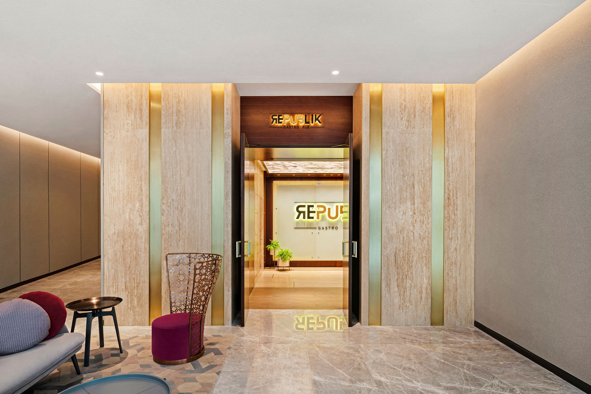 Lobby med moderne indretning, inkluderer siddepladser og indgang til Republik Gastro Pub. (AI-genereret tekst)