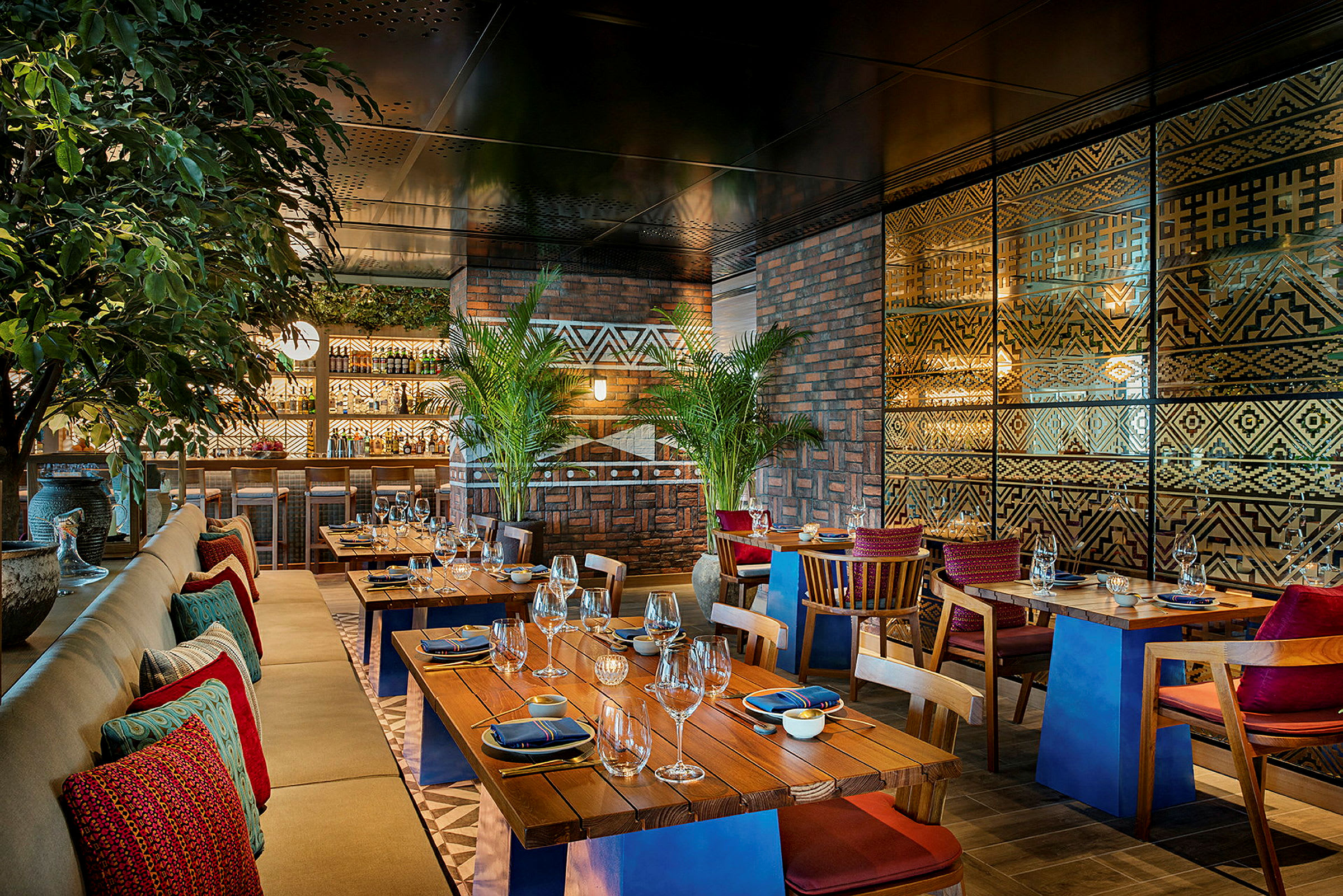 Interiør af en restaurant med træborde, polstrede stole og dekorativ vægdesign. (AI-genereret tekst)