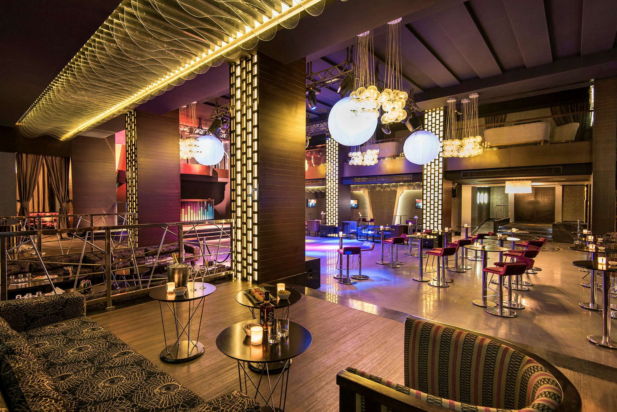 En moderne restaurant med borde og stole samt dekorative lyshæng. (AI-genereret tekst)