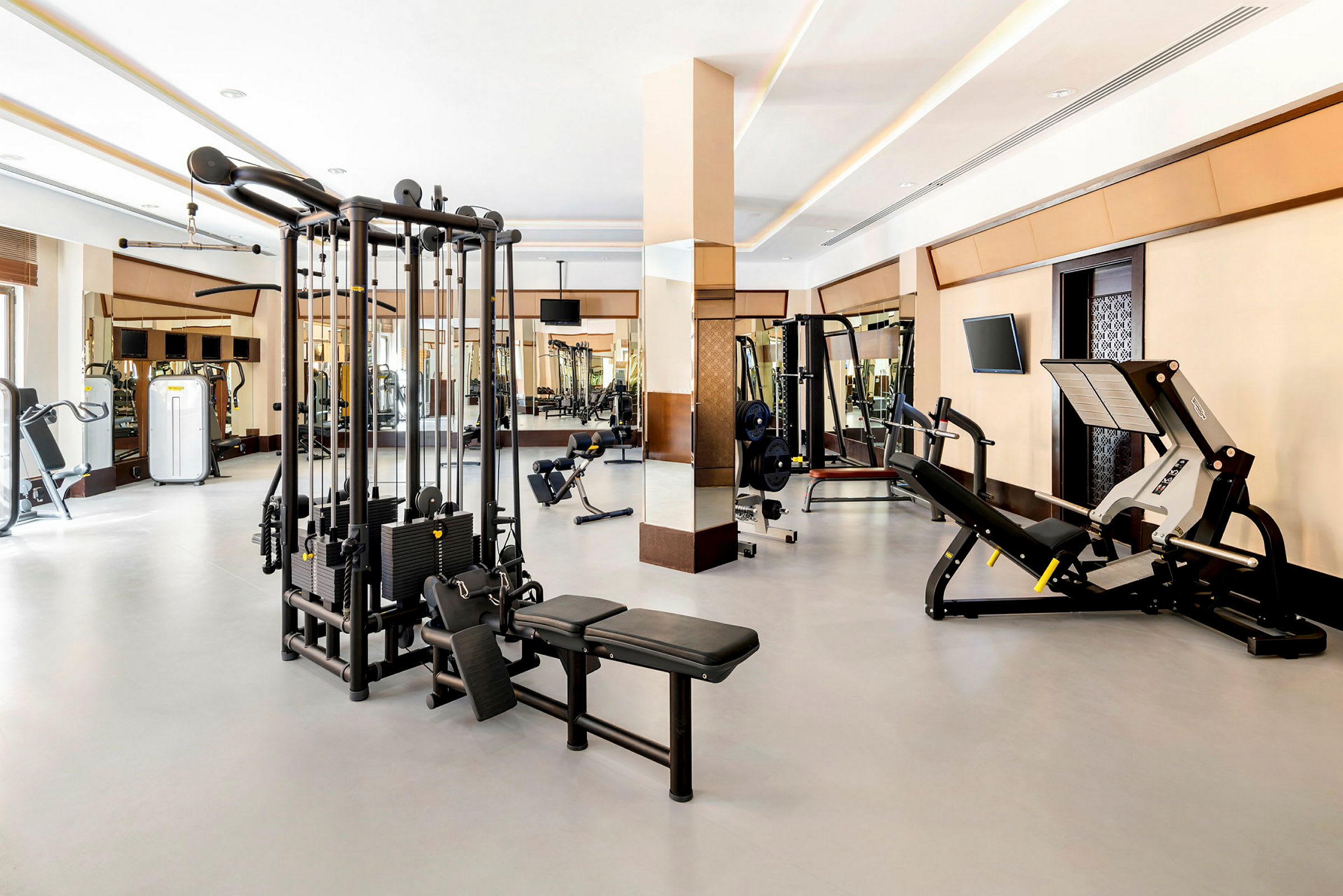Billede af et fitnesscenter med forskellige træningsmaskiner og frie vægte. (AI-genereret tekst)