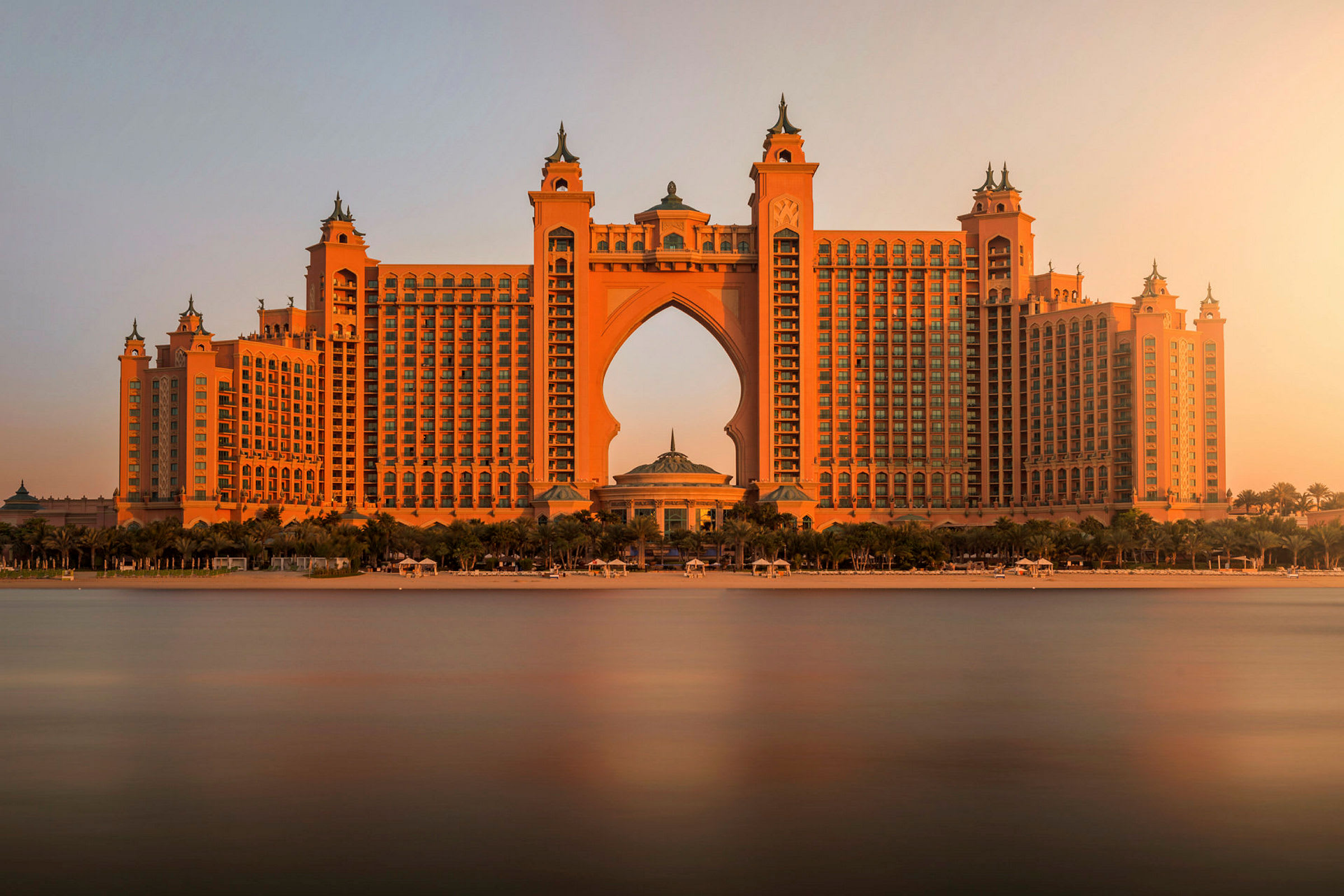 Et stort hotel med arabiske arkitektoniske detaljer ved solnedgang. (AI-genereret tekst)