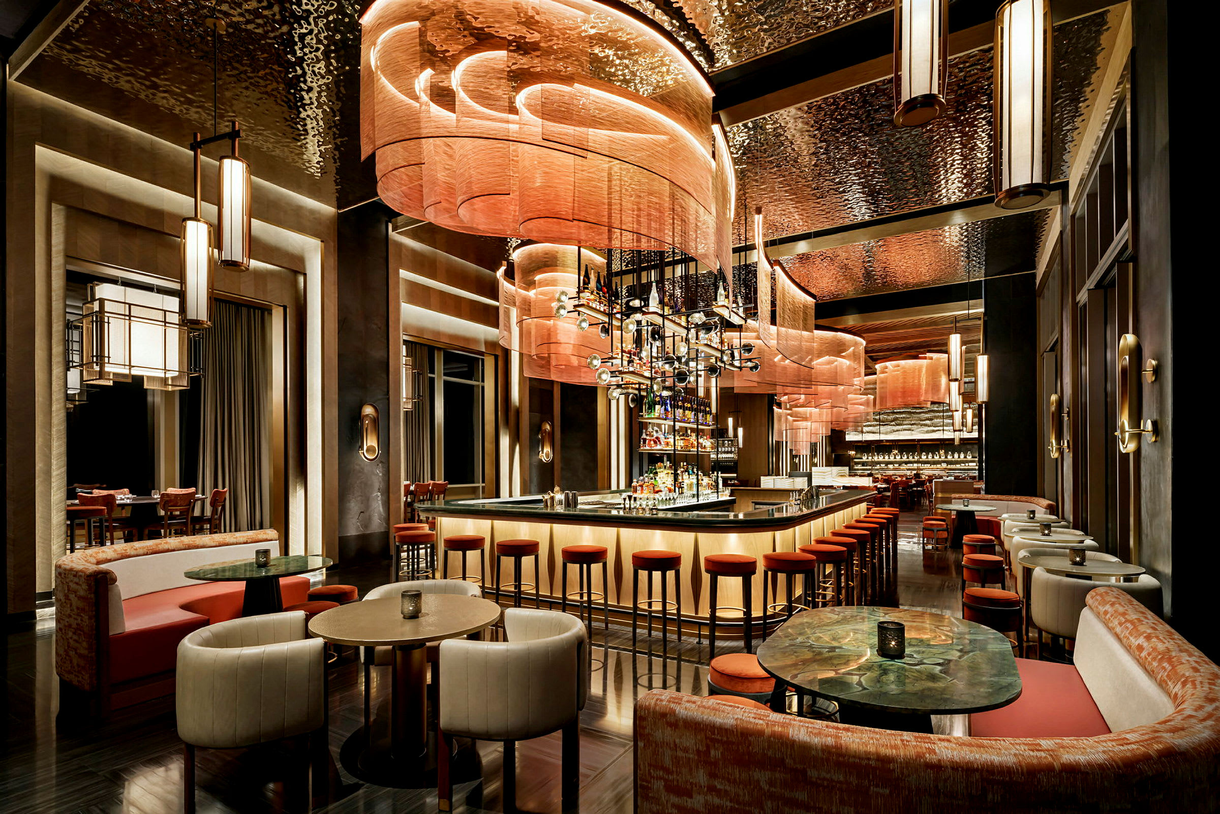 En elegant hotelbar med sofaer, borde og høje stole ved en lang bardisk. (AI-genereret tekst)