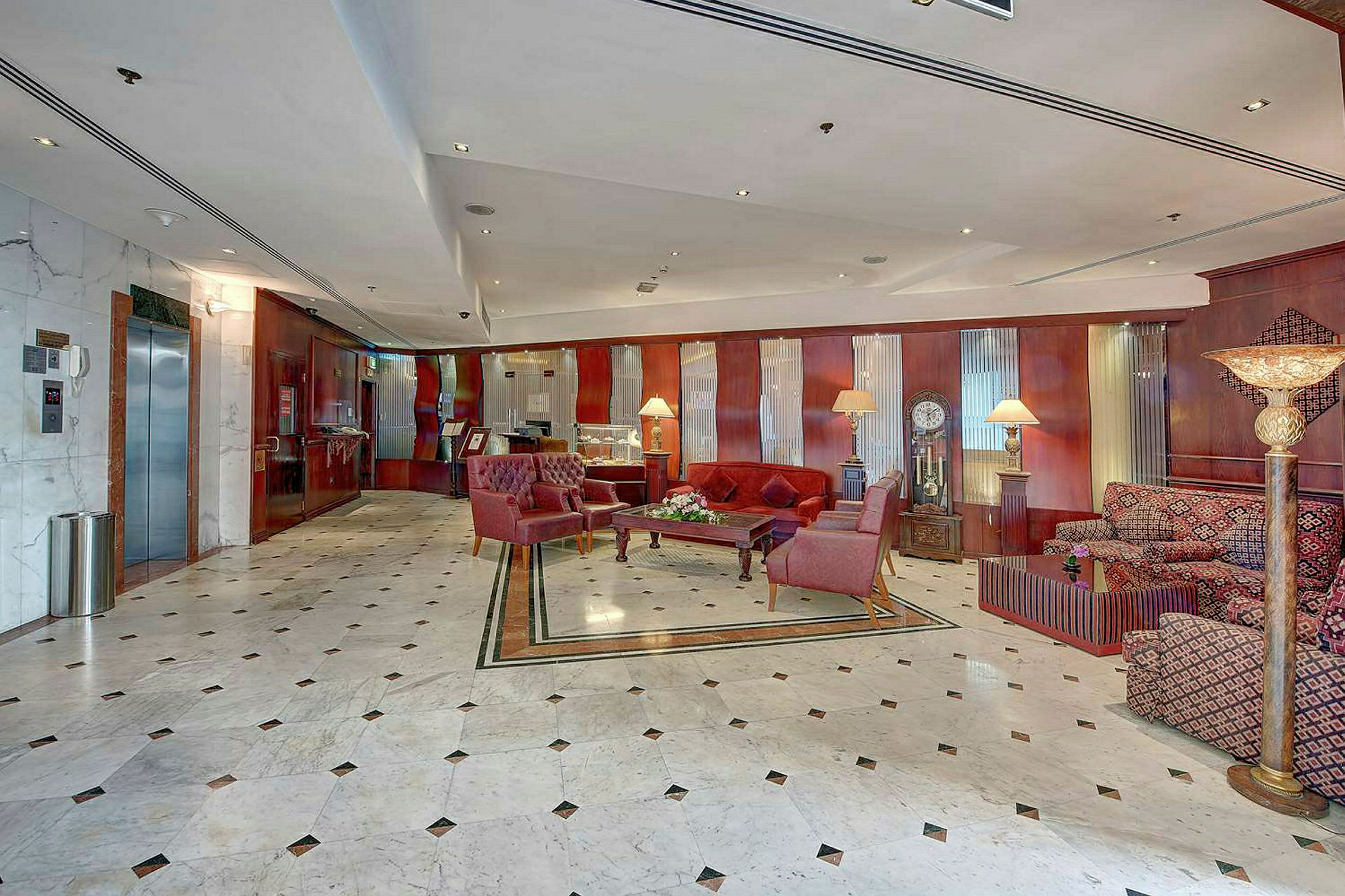 En rummelig hotellobby med marmorgulve og møbler med komfortable lænestole og sofaer. (AI-genereret tekst)