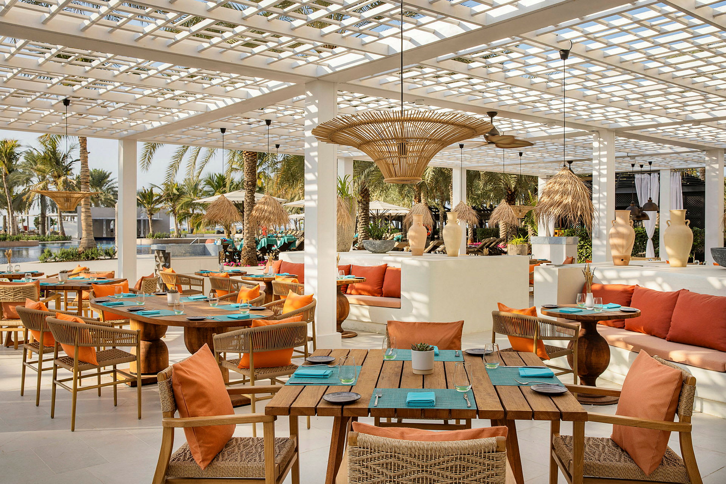Restaurant med trémøbler og orange puder på terrasse. (AI-genereret tekst)