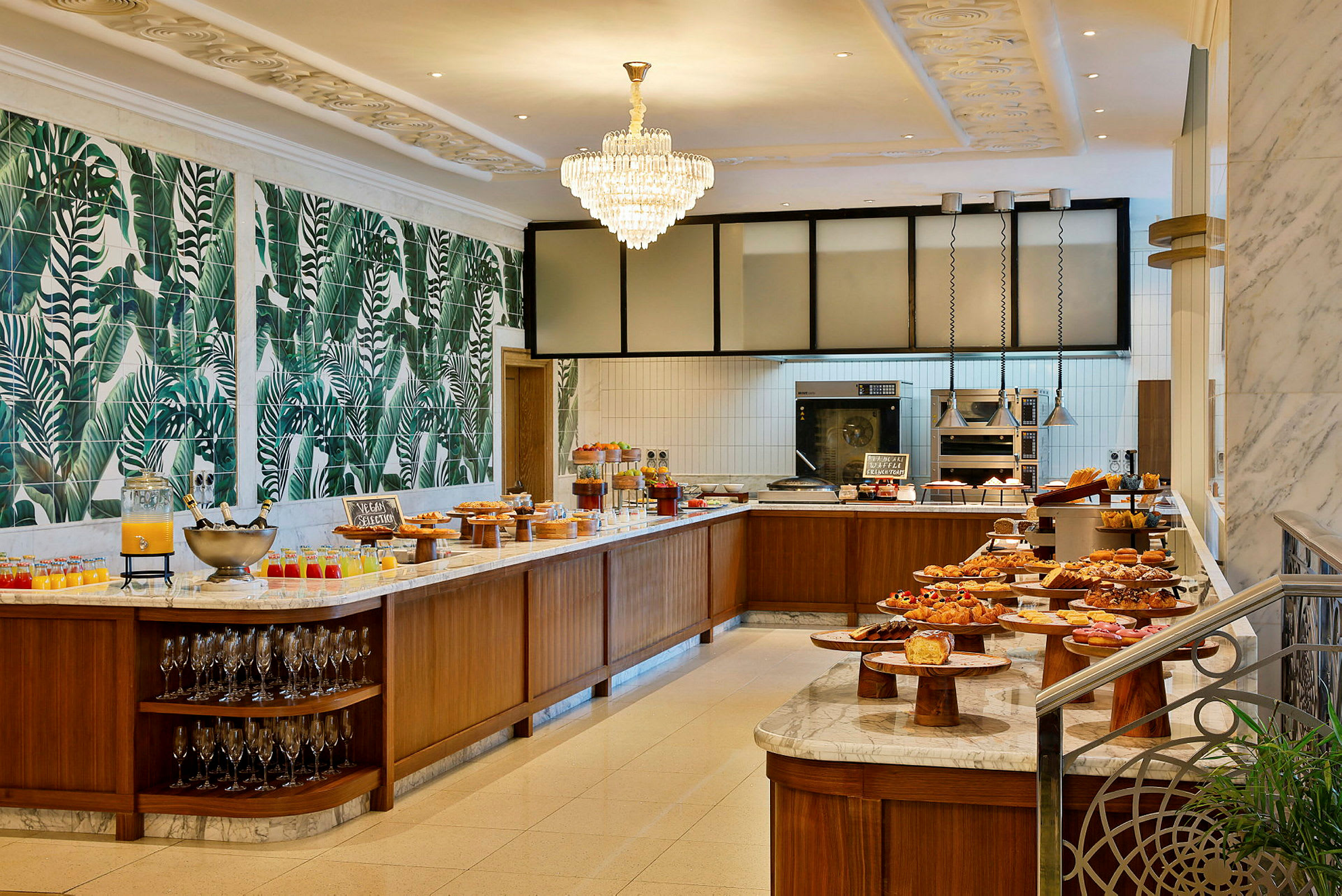 En buffet med forskellige madvarer og drikkevarer opstillet på et marmorbord i en smagfuldt dekoreret lokale. (AI-genereret tekst)
