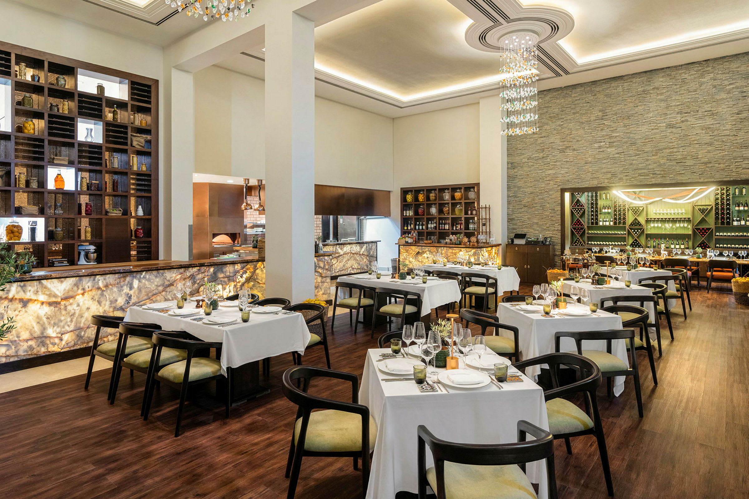 En elegant restaurant med dækkede borde, stole og en oplyst bar. (AI-genereret tekst)