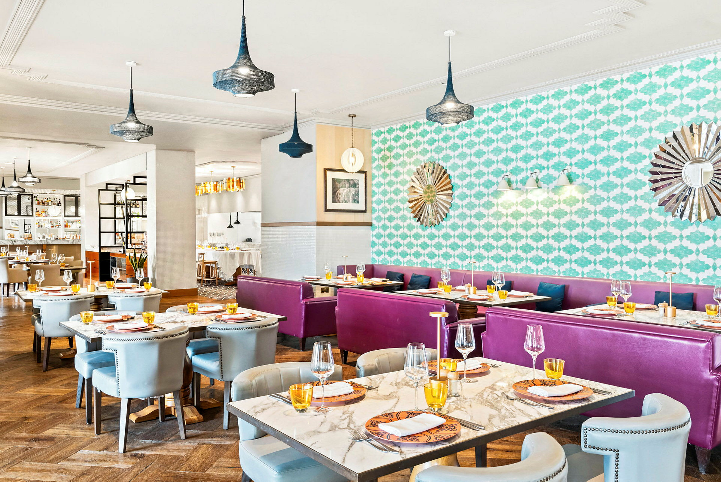 Restaurant med borde og stole, farverig indretning og dekorationer på væggene. (AI-genereret tekst)