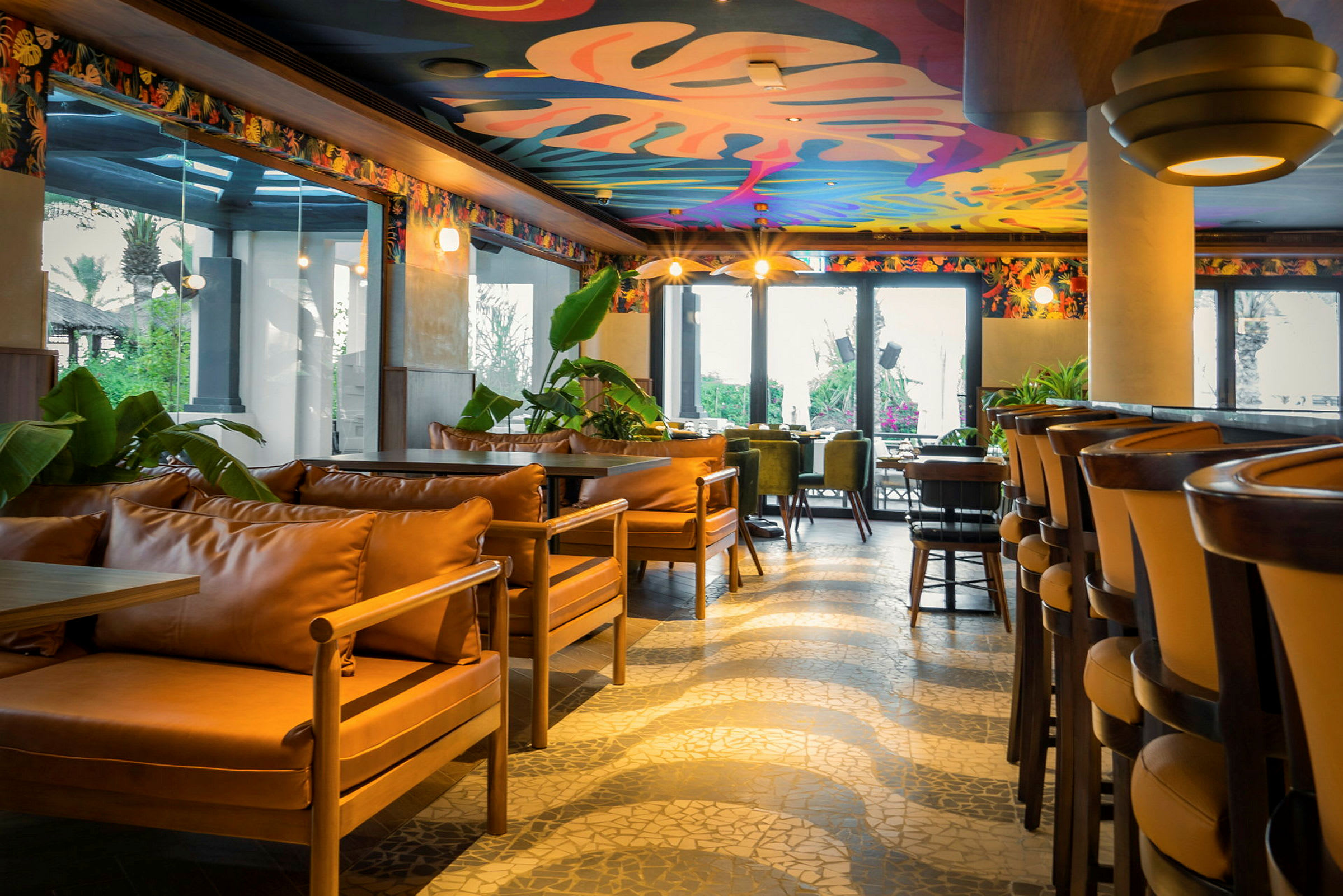 En lys restaurant med farverigt dekoreret loft og moderne siddepladser. (AI-genereret tekst)