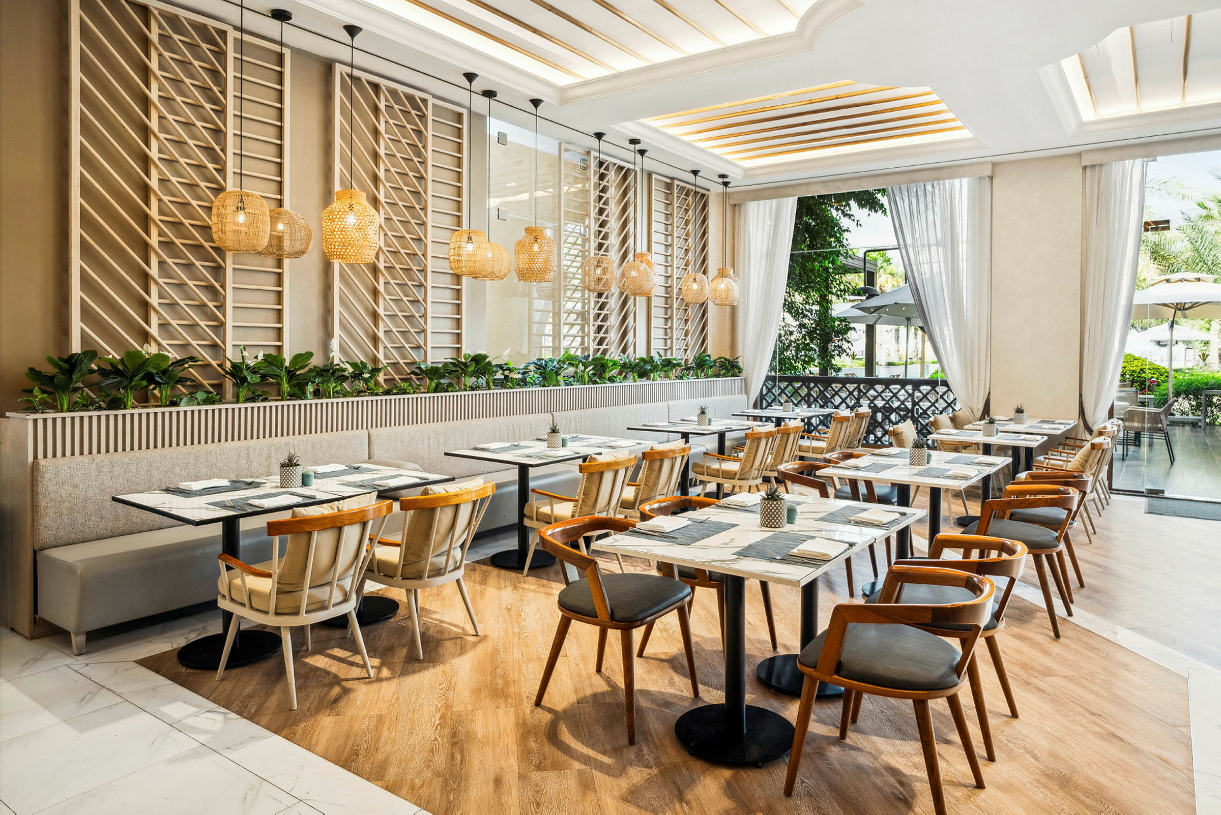 En moderne, lyst indrettet restaurant med træmøbler og store vinduer, der lukker naturligt lys ind. (AI-genereret tekst)