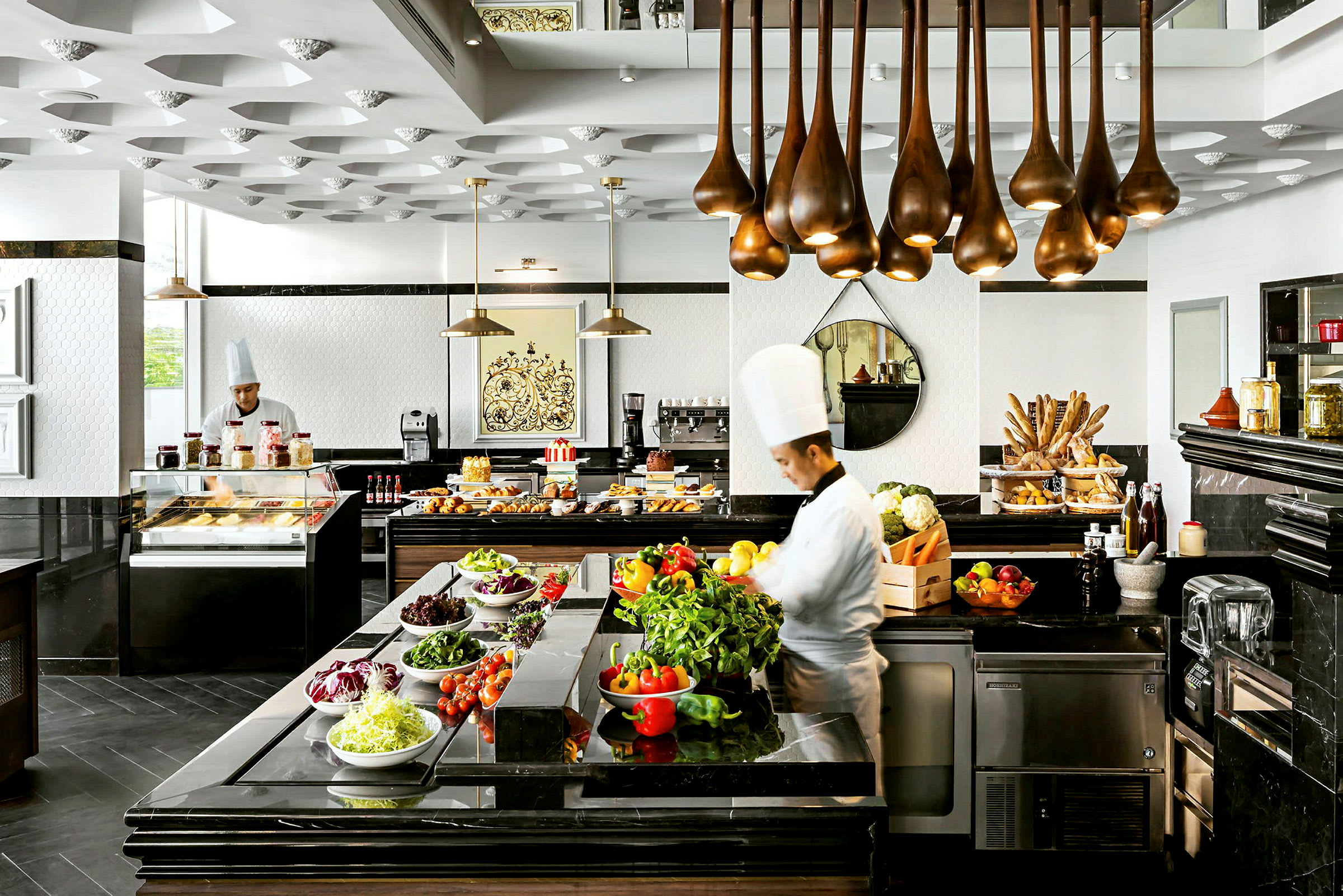 En stilfuld buffet med forskellige friske grøntsager, bagværk og ingredienser i et moderne restaurantkøkken. (AI-genereret tekst)