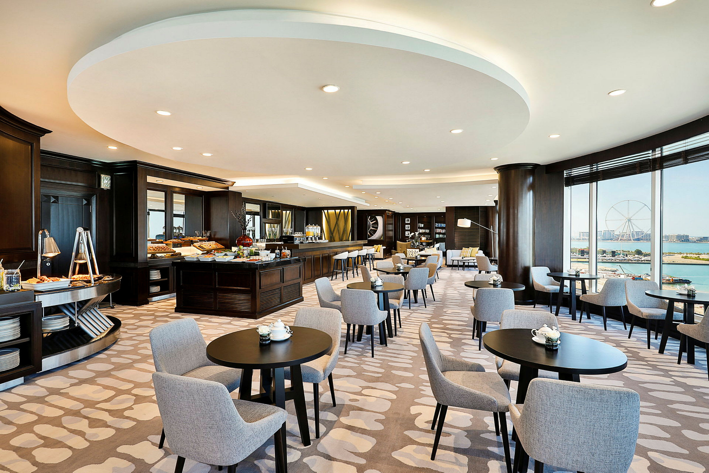 Interiør af en elegant restaurant med borde og stole samt et buffetområde. (AI-genereret tekst)