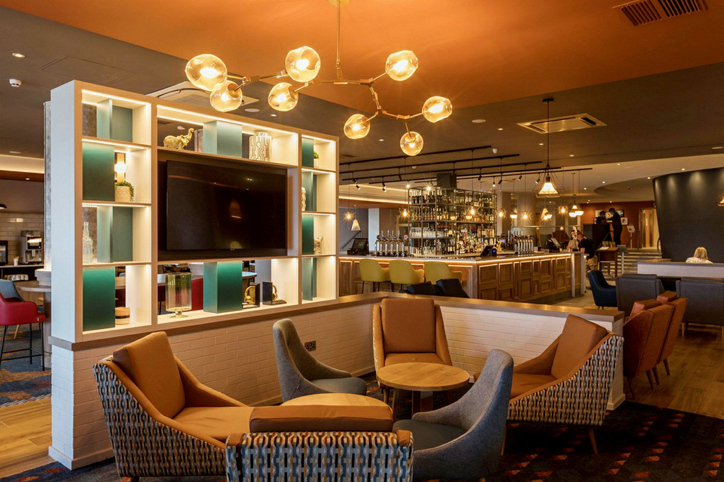 Et moderne hotelområde med en bar, siddepladser og indretning i lyse farver. (AI-genereret tekst)