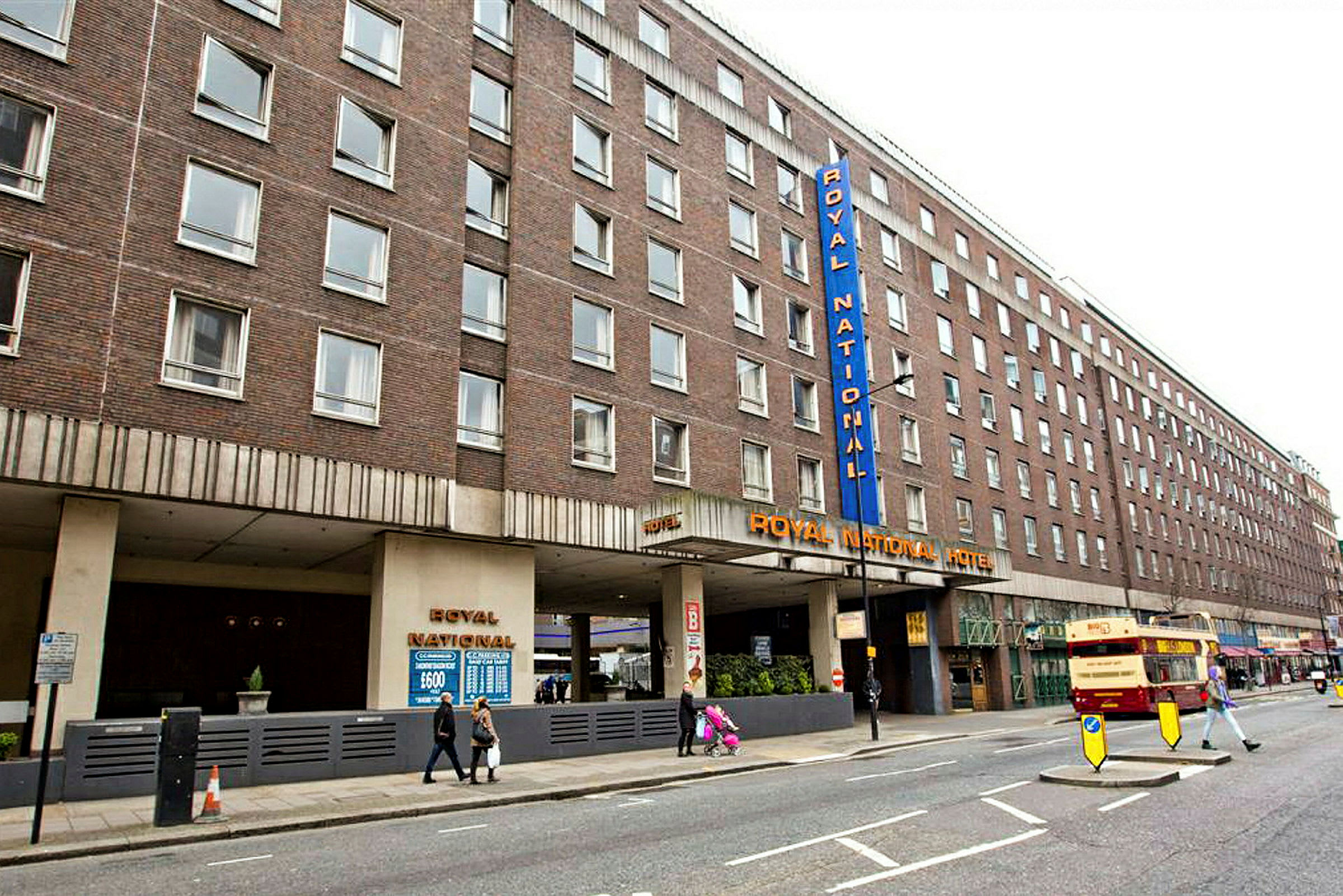 Et billede af Royal National Hotel i London, bygningen er brun og har flere vinduer. (AI-genereret tekst)