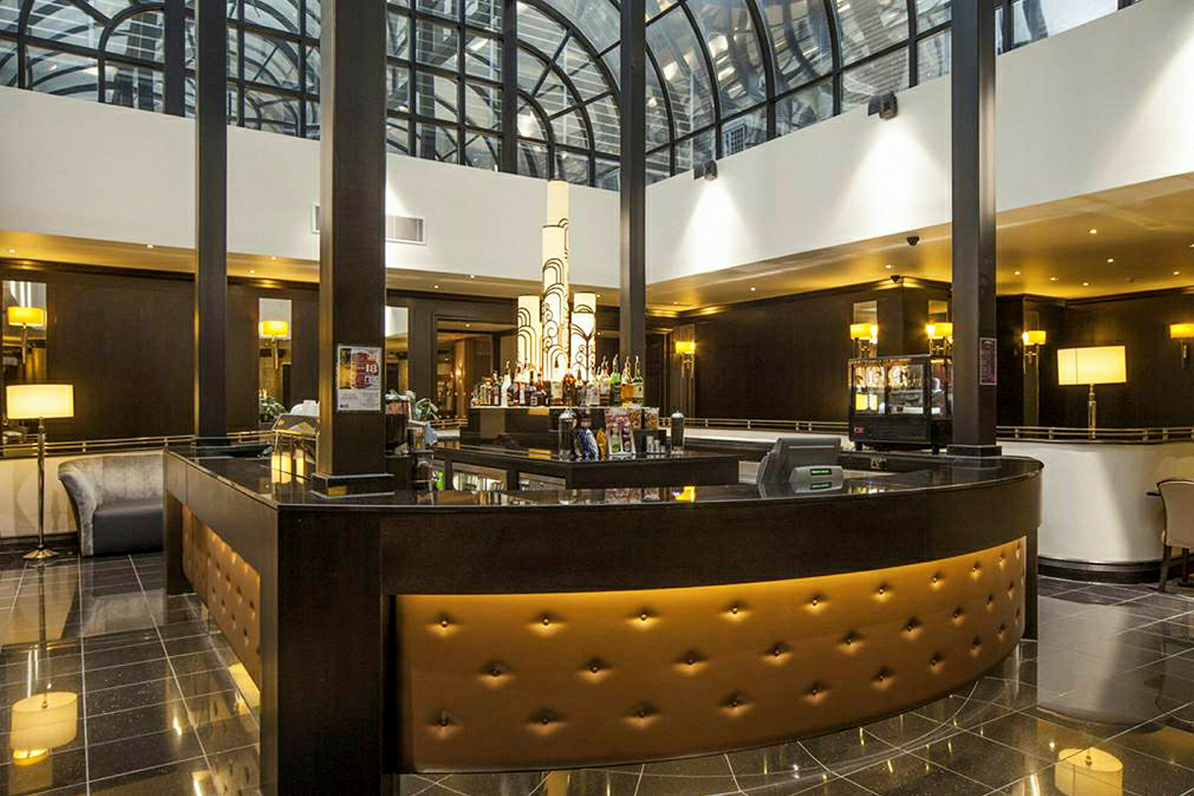 Hotelbar med elegant indretning og ovenlysvindue. (AI-genereret tekst)