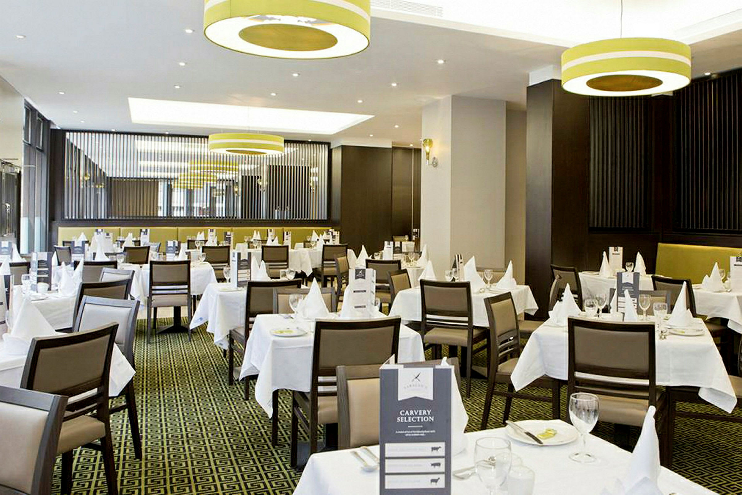 En elegant restaurant med hvide duge og borddækning. (AI-genereret tekst)