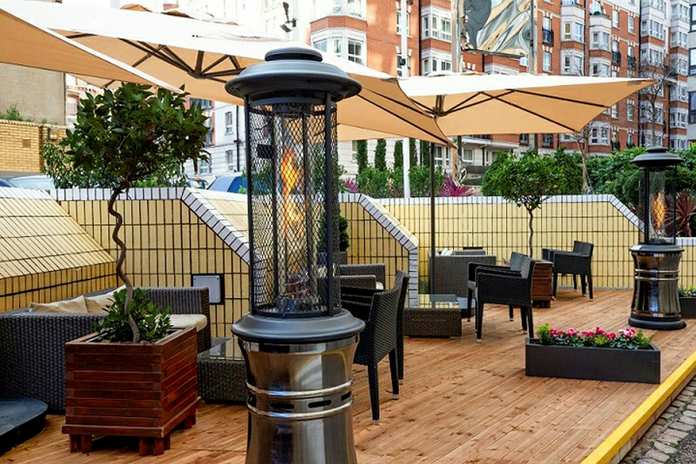 Terrasse med møbler og varmeapparat på en træterrasse. (AI-genereret tekst)