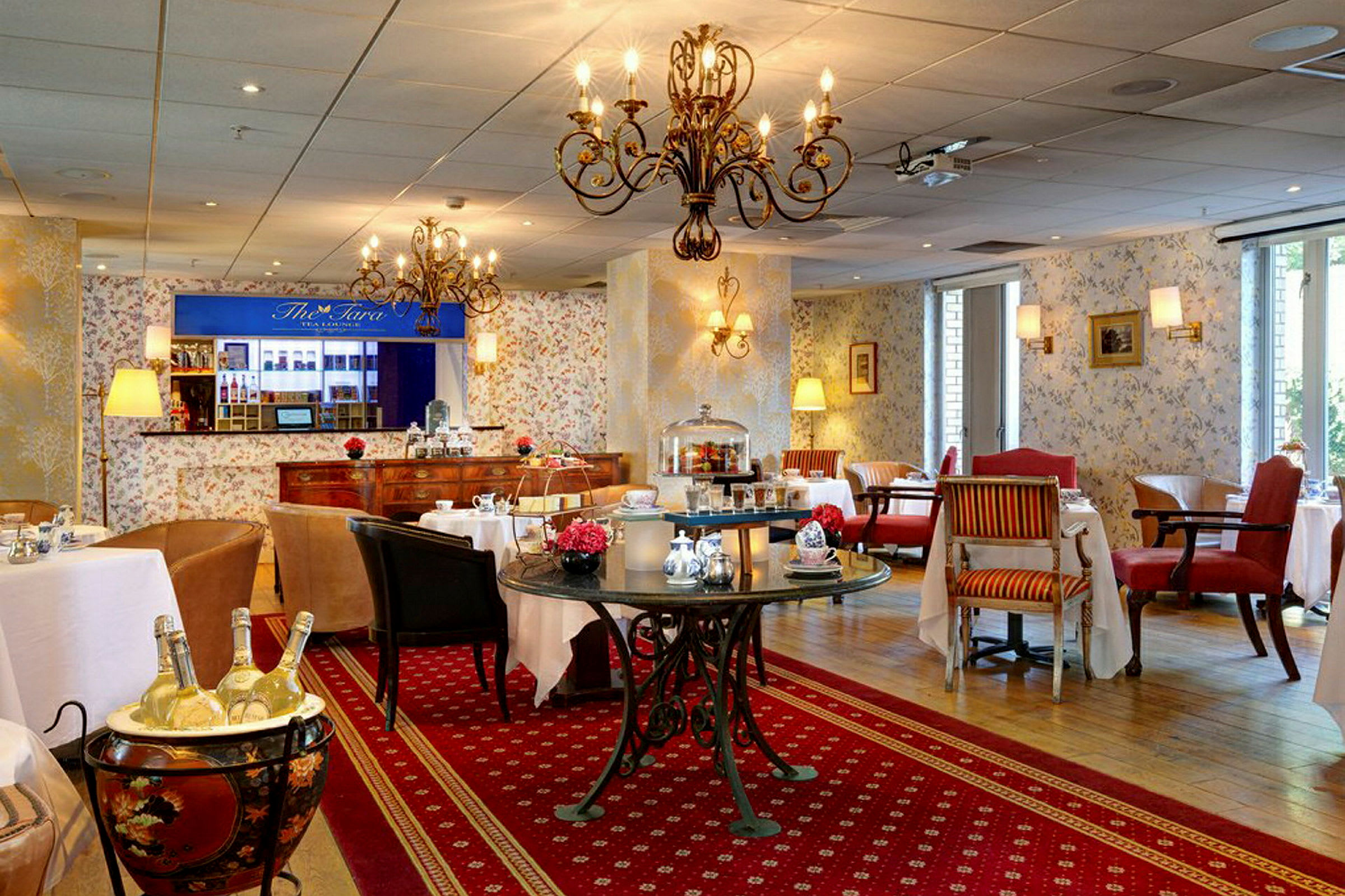 Billede af en elegant restaurant med dækkede borde og stole på et mønstret tæppe. (AI-genereret tekst)