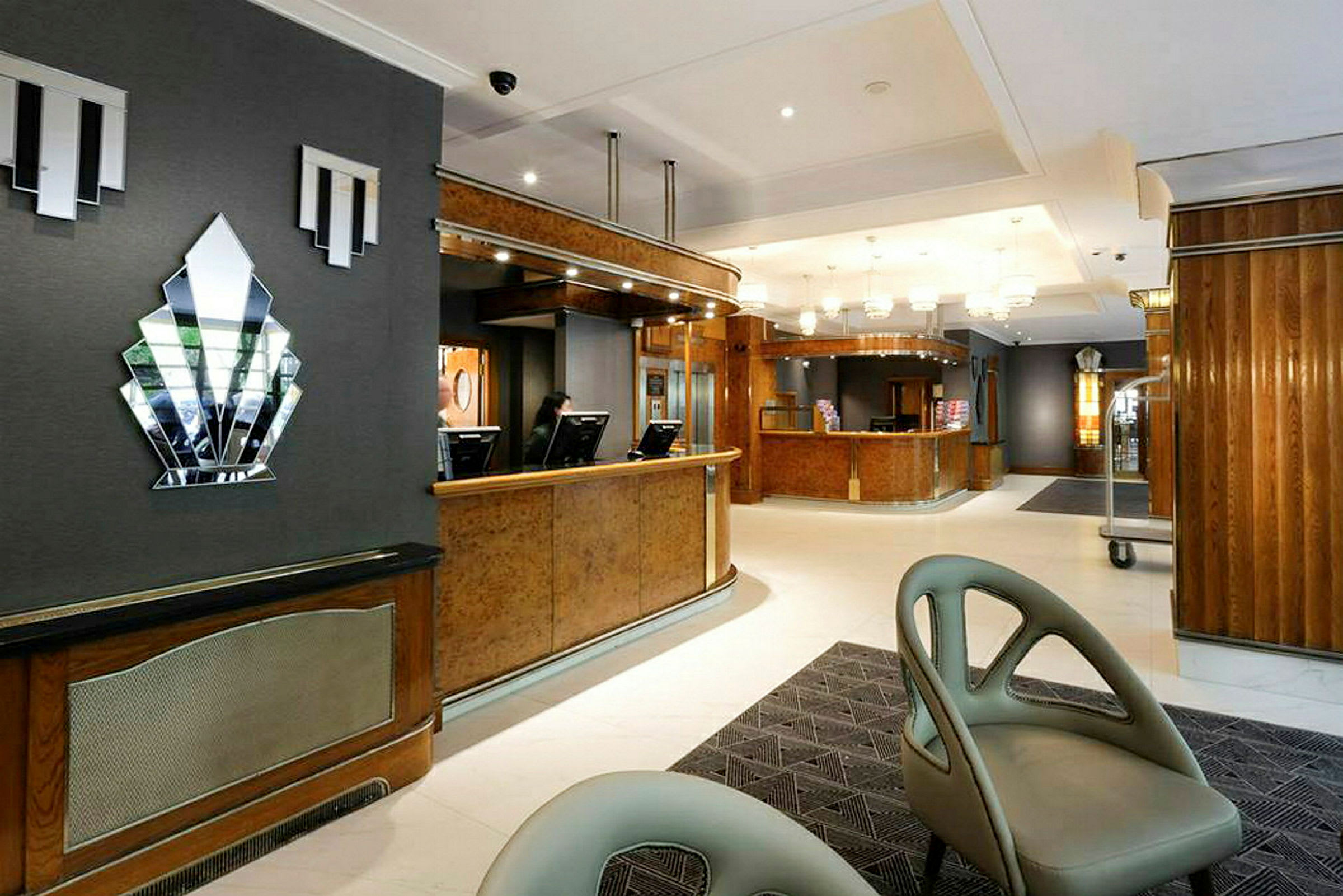 Billede af en hotelreception med trædetaljer og moderne møbler. (AI-genereret tekst)