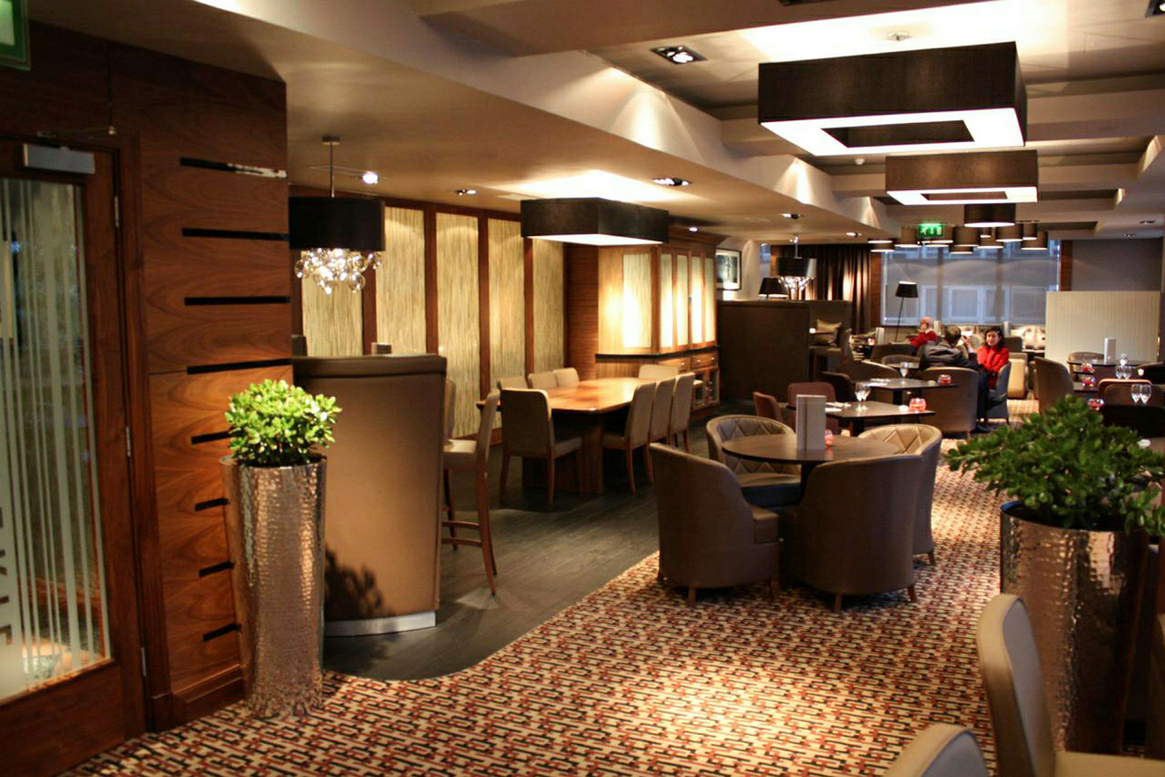 Interiør af en restaurant eller lounge med borde, stole og elegant dekoration. (AI-genereret tekst)