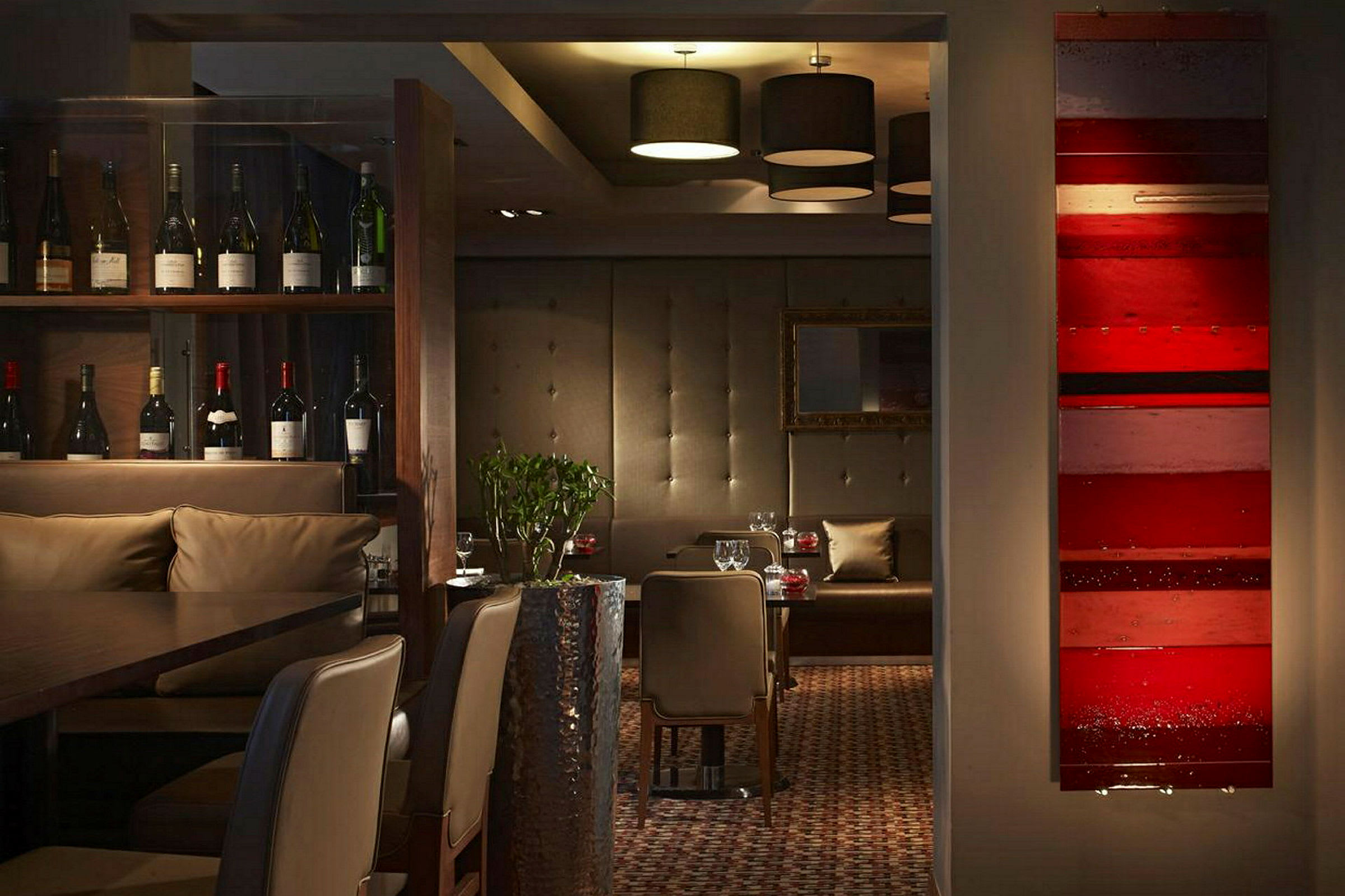 Interiør af en restaurant med vinflasker, siddepladser og dekorative detaljer. (AI-genereret tekst)