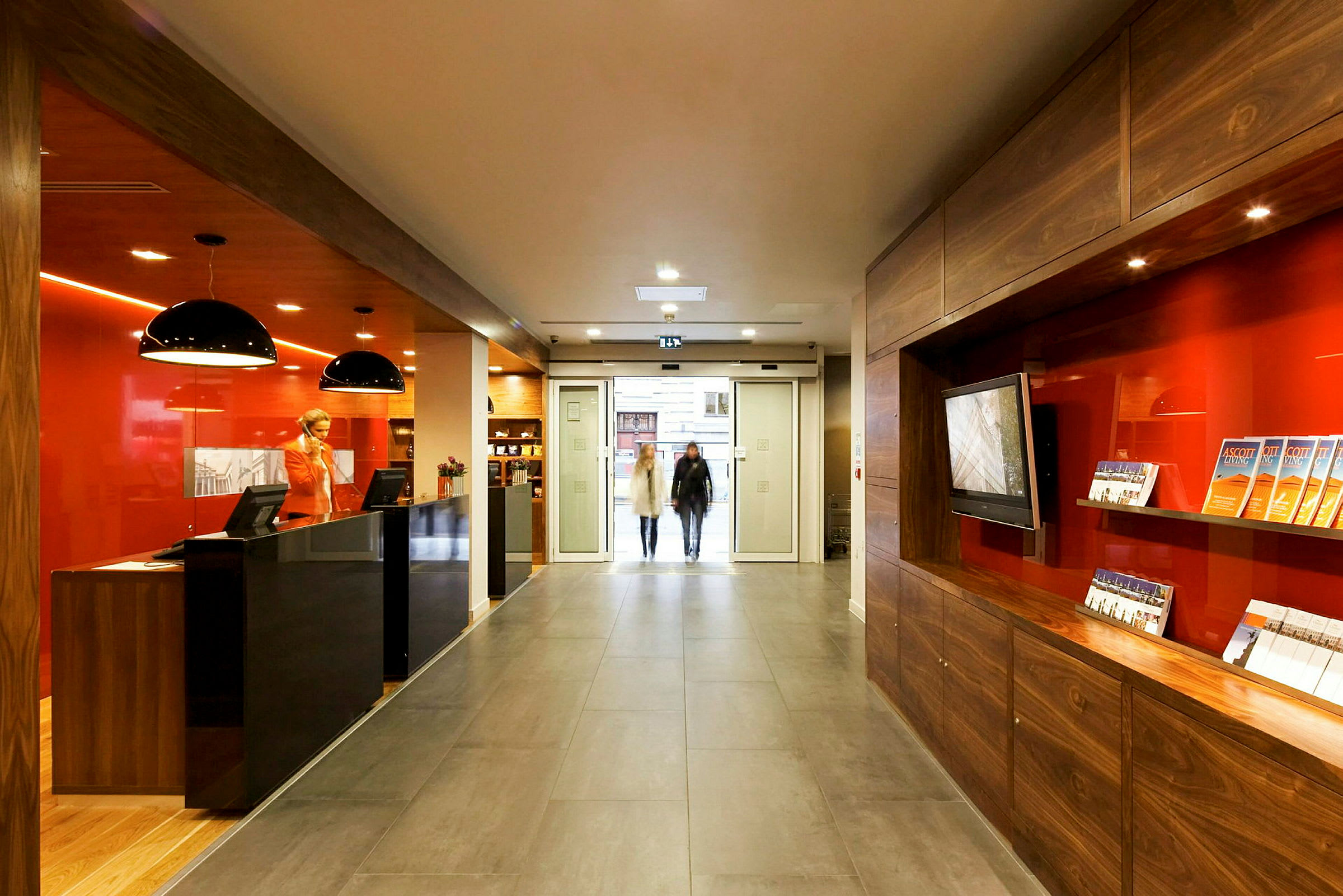 Reception med moderne indretning og informationsbrochurer, beliggende nær en glassentré. (AI-genereret tekst)
