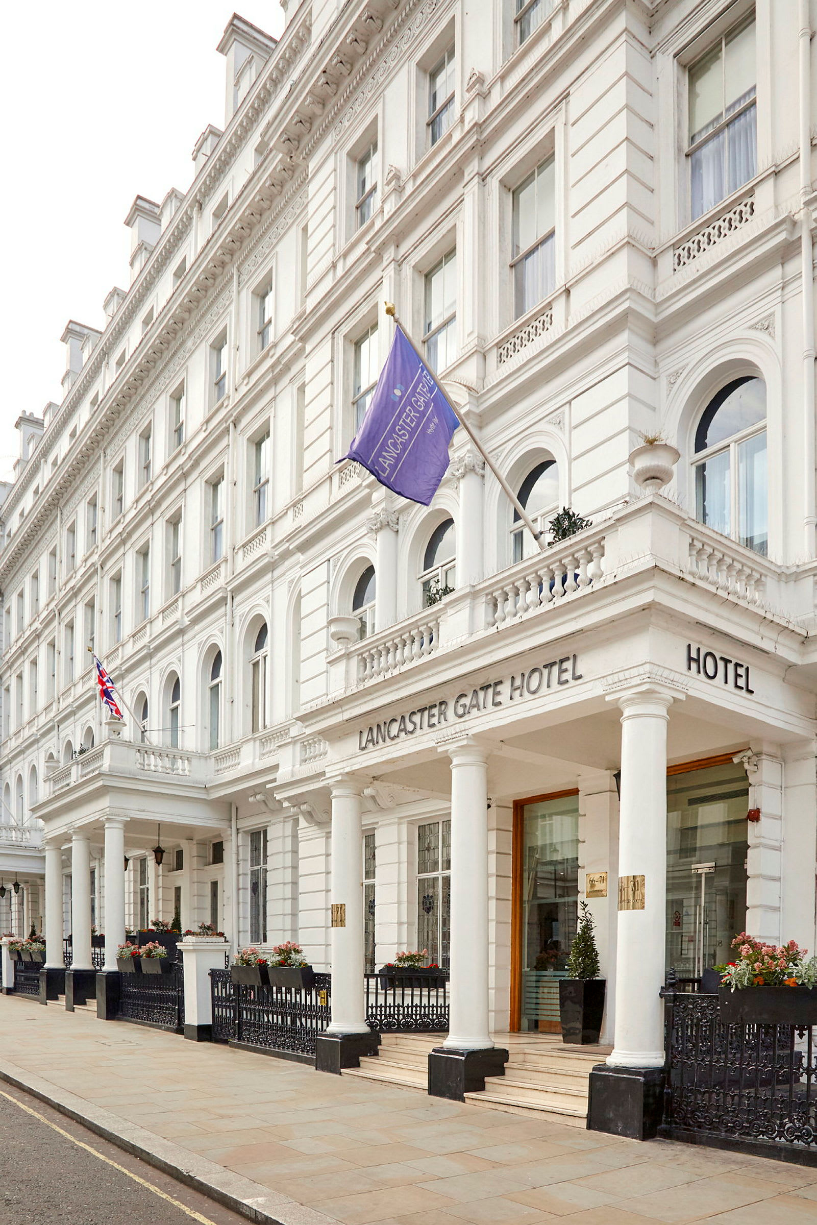 Hotellet Lancaster Gate set fra gaden, med hvide detaljer og søjler. (AI-genereret tekst)