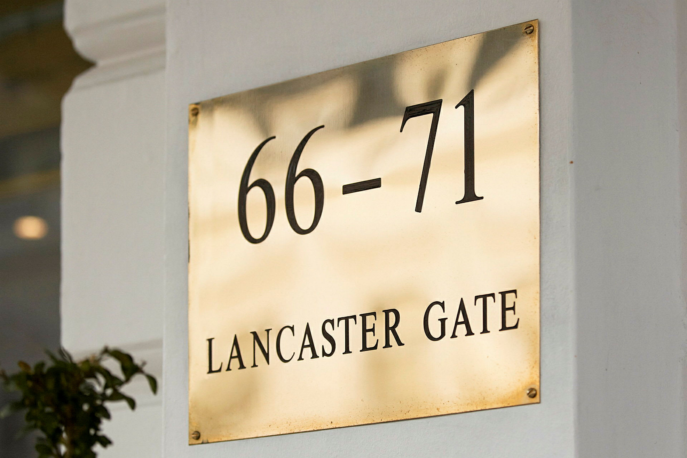 Skilt med teksten 66-71 Lancaster Gate. (AI-genereret tekst)