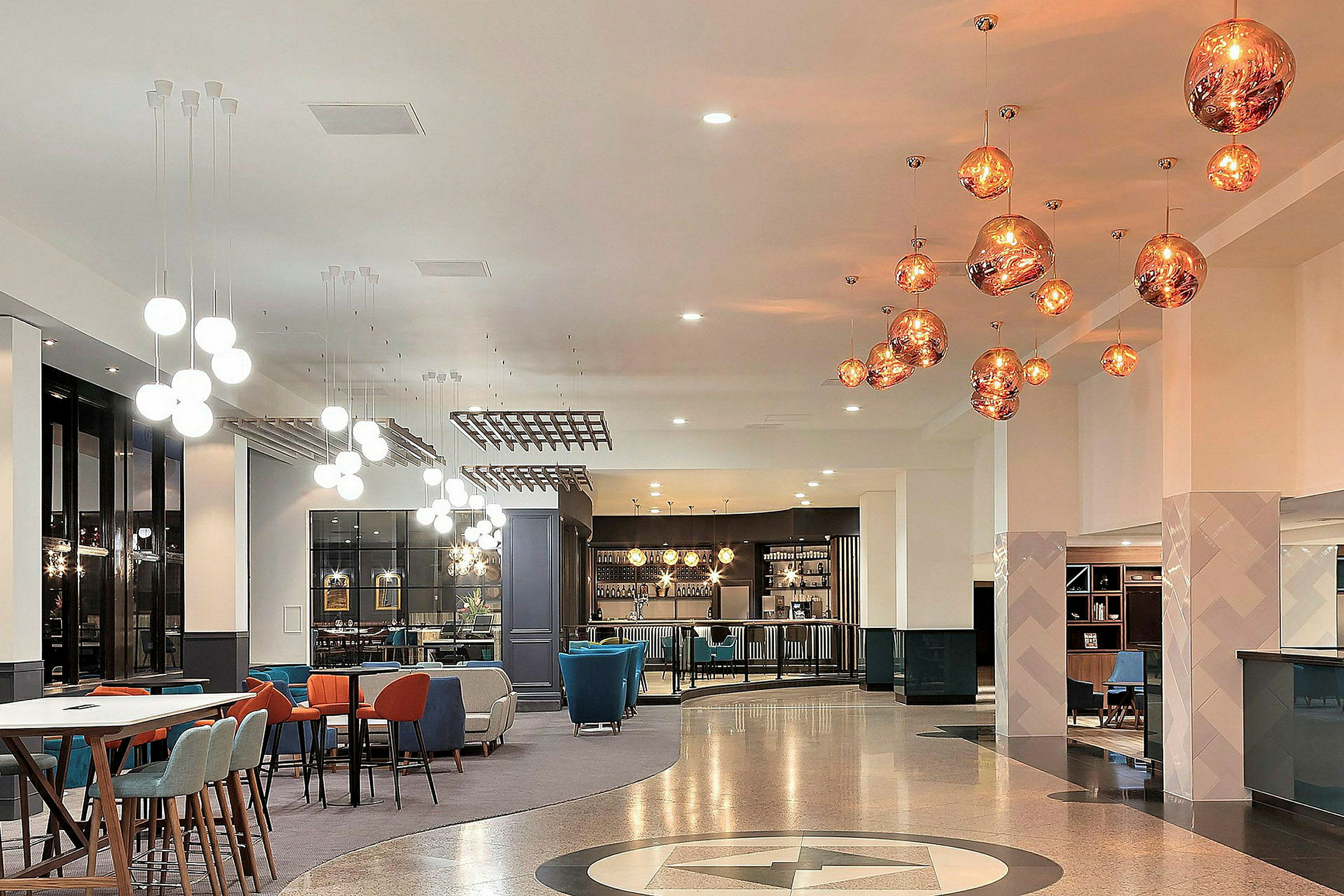 En moderne hotellobby med siddepladser og hængende loftslamper. (AI-genereret tekst)