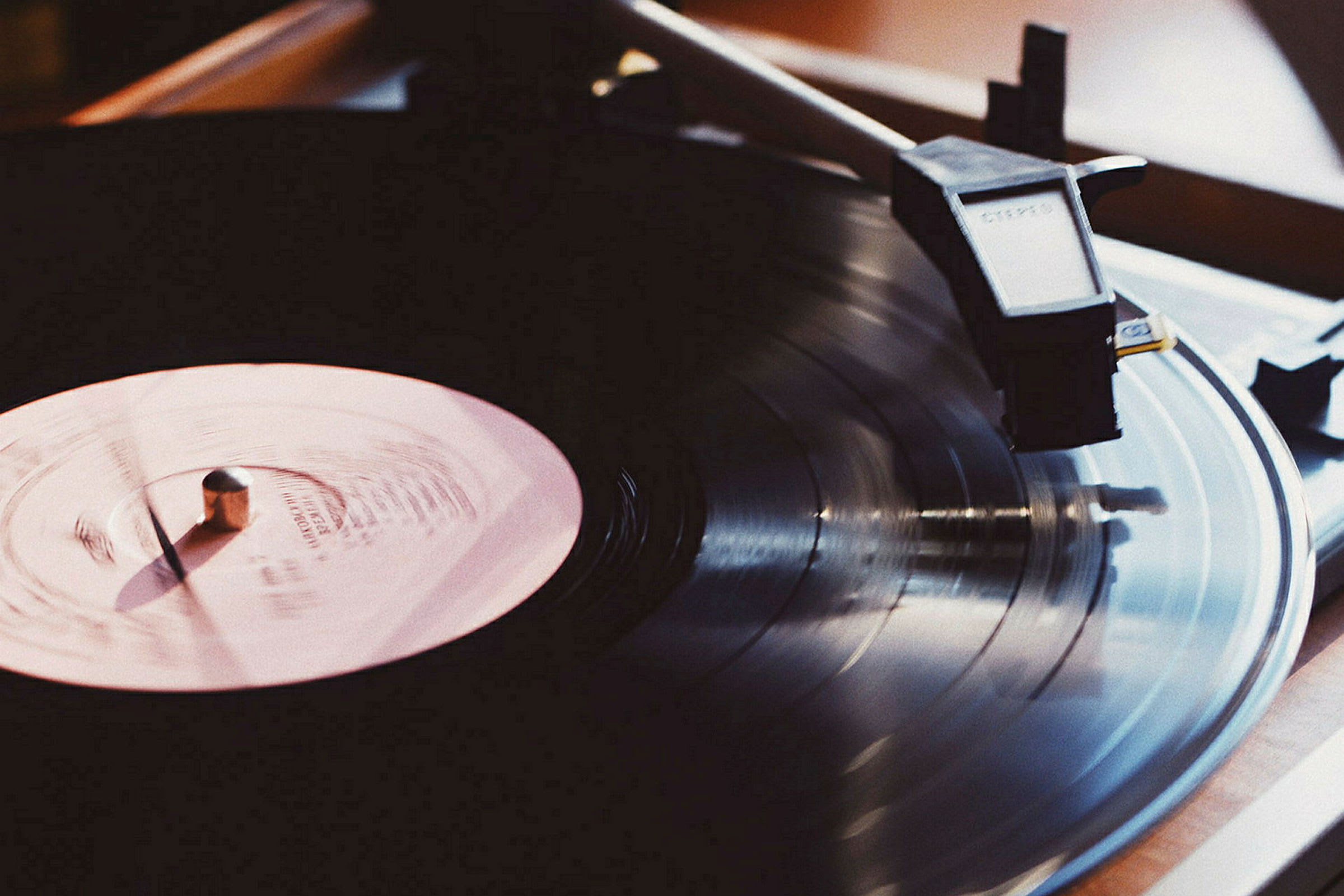 Nærbillede af en vinylplade, der spilles på en pladespiller. (AI-genereret tekst)
