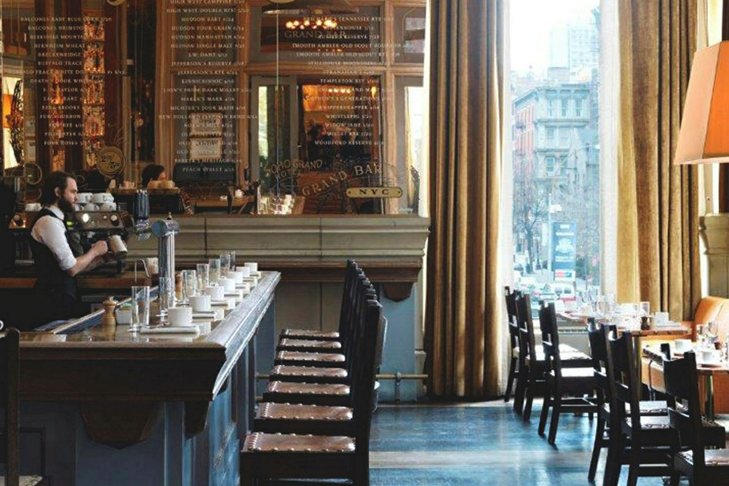 Billede af et smagfuldt indrettet cafémiljø med en kaffebar, siddepladser og store vinduer, der lukker naturligt lys ind. (AI-genereret tekst)