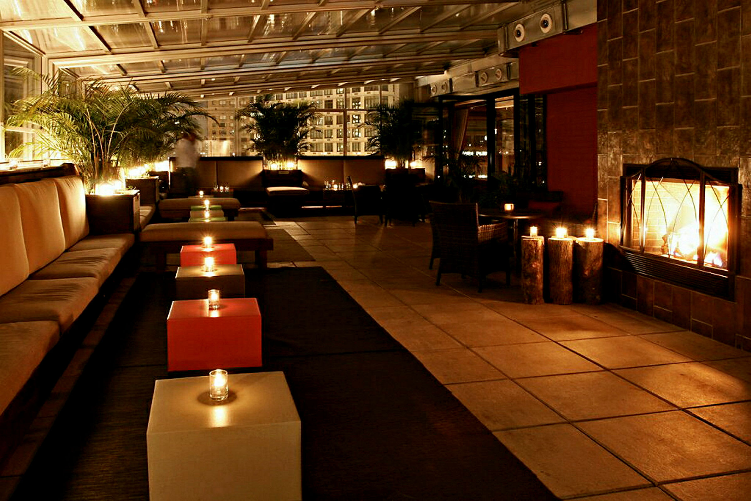 Et moderne oplyst loungeområde med sofaer, lave borde og en brændende pejs. (AI-genereret tekst)
