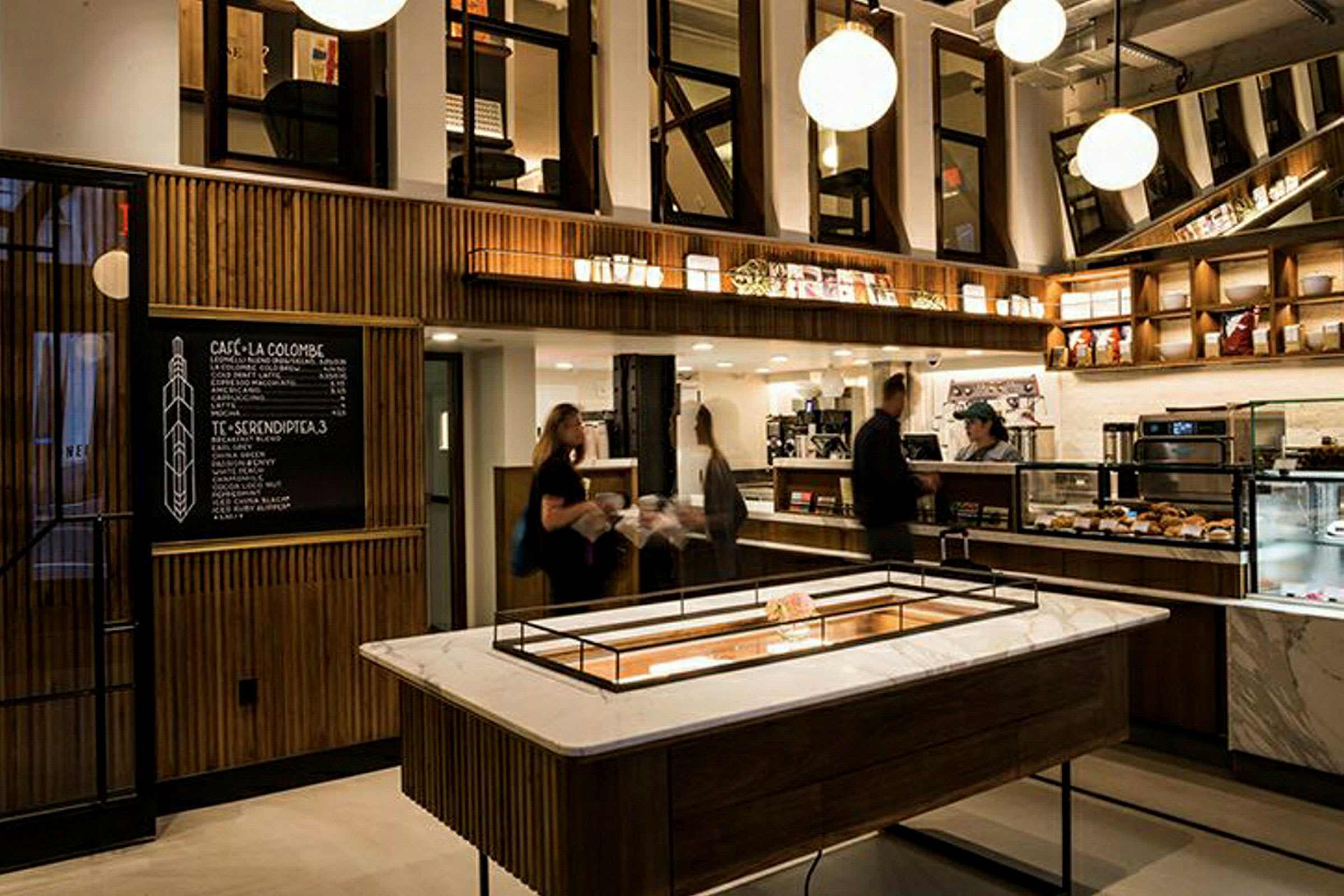 Billede af en moderne kaffebar med elegant interiør, vægmonterede hylder og en menu på en sort tavle. (AI-genereret tekst)