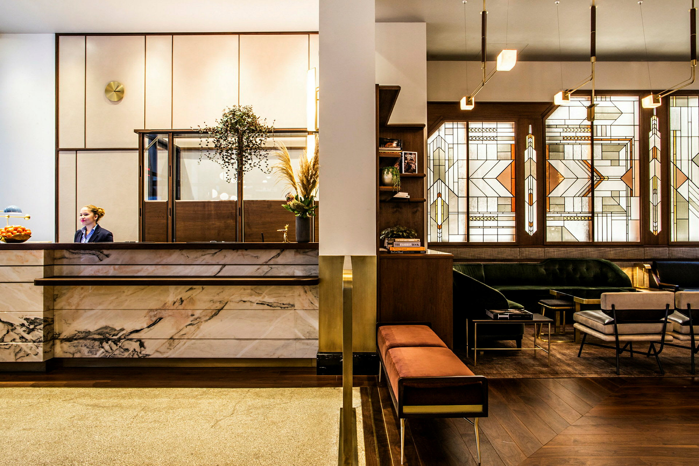 Reception og loungeområde på et hotel, med marmorbord og interiør i varme nuancer. (AI-genereret tekst)