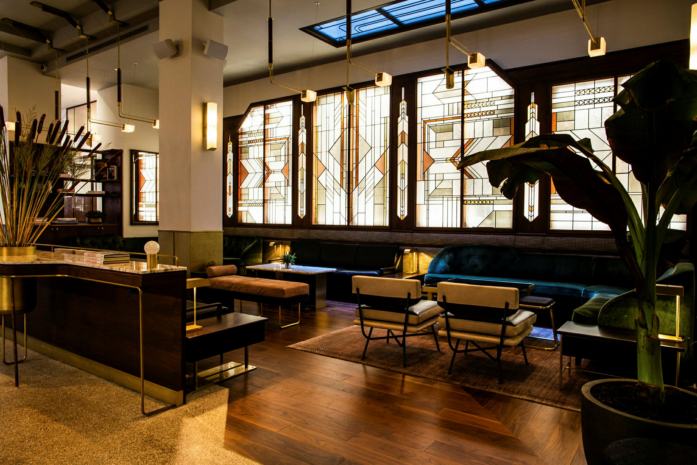 Et elegant indrettet rum med art deco-inspirerede glasvinduer, komfortable siddepladser og et receptionsområde. (AI-genereret tekst)